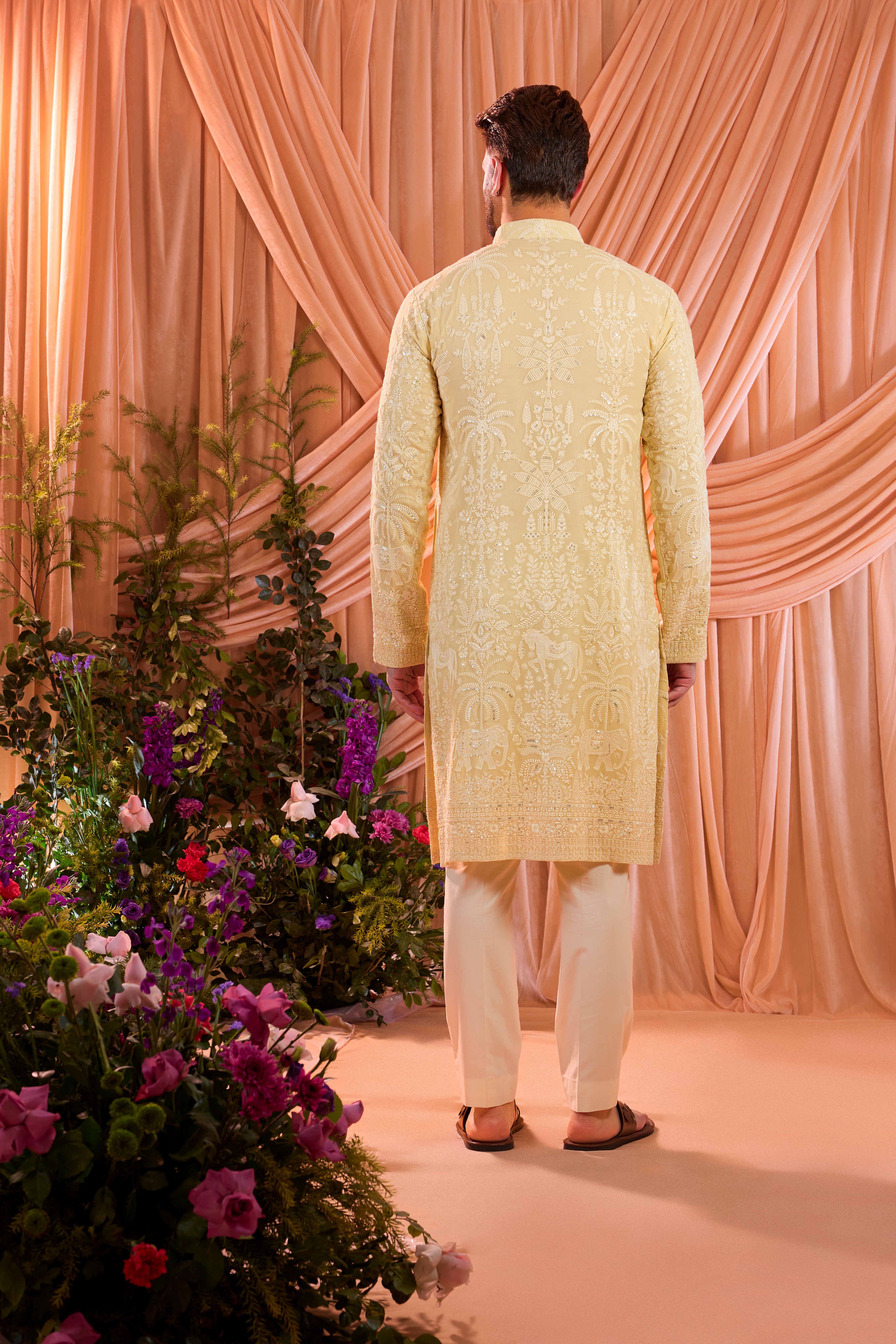 A pastel yellow kurta illuminated with delicate sequins, brought to life by intricate flora and fauna embroidery.