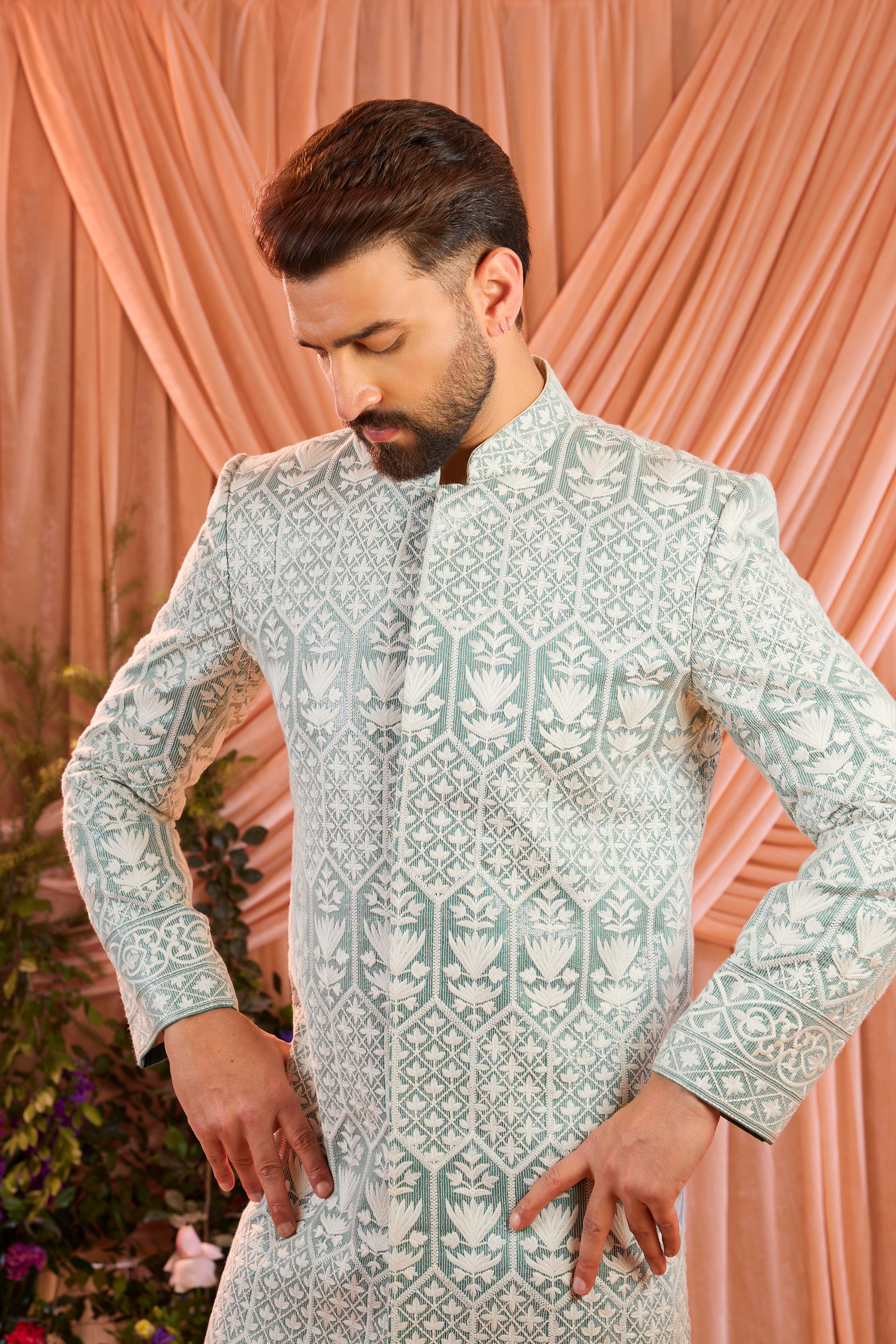 An aqua blue chikankari sherwani distinguished by heavy ivory threadwork and meticulously detailed sequin embellishment.