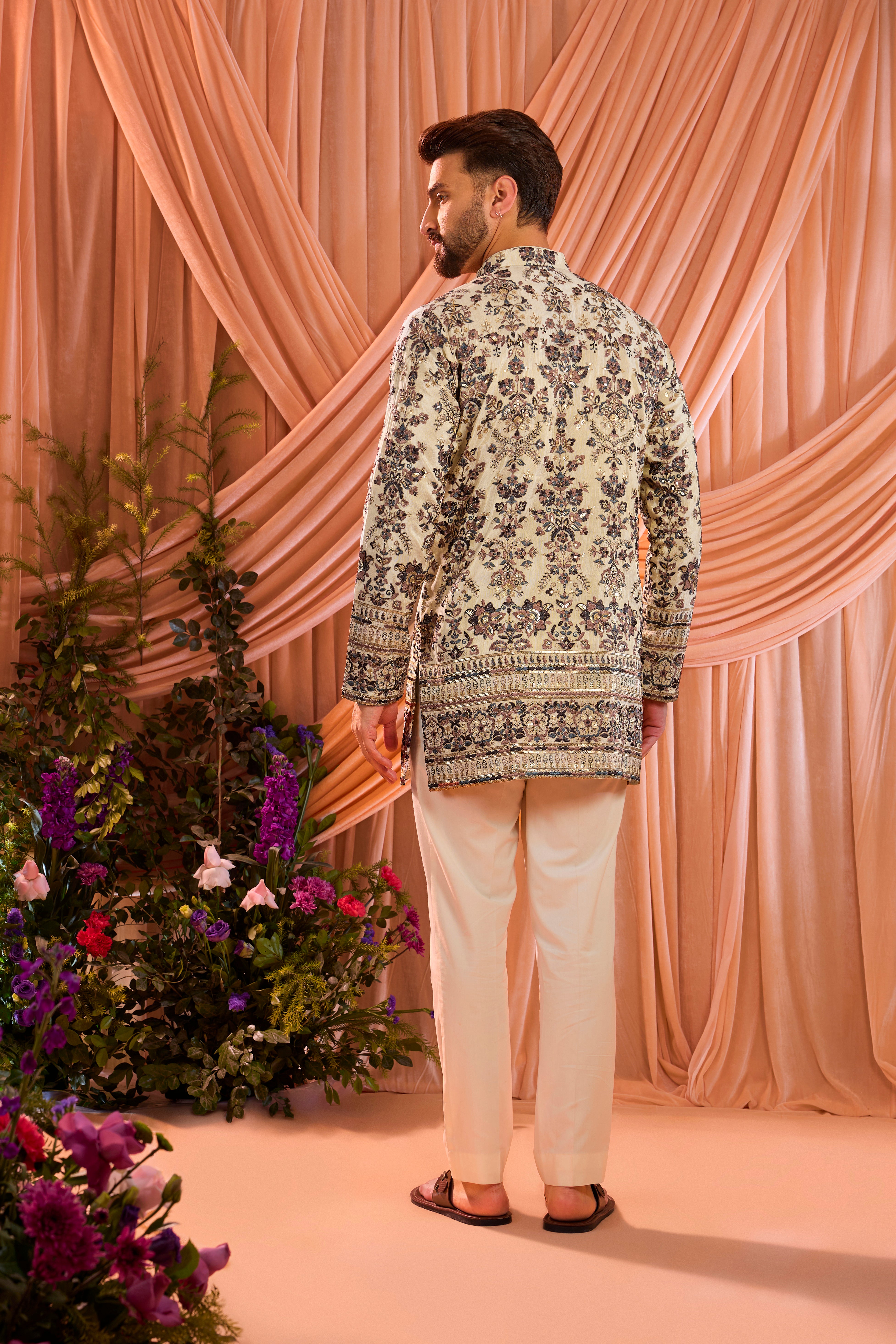 A light golden short floral chikankari kurta accented with delicate multi threadwork, enriched by zari and subtle sequin detailing.