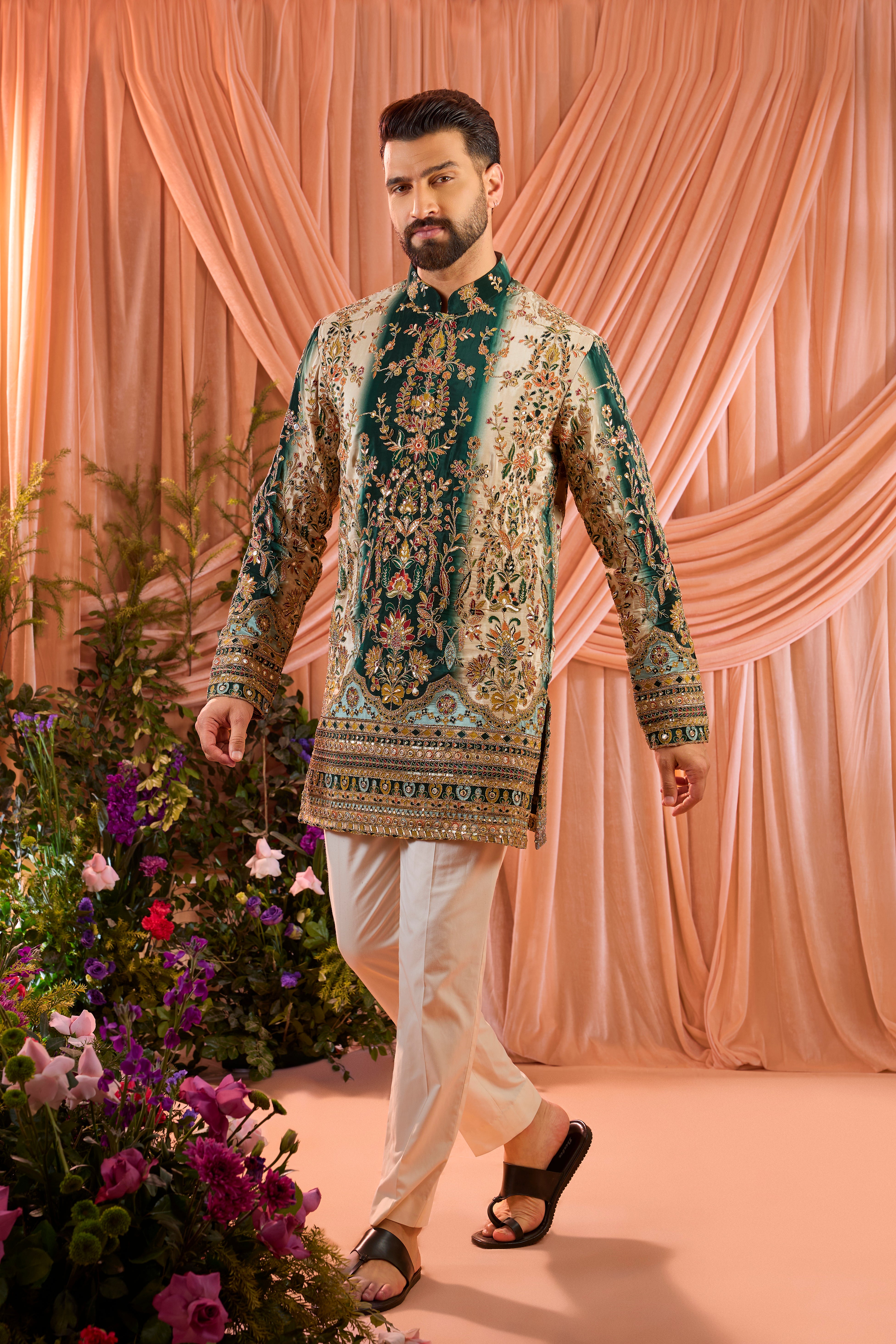 A green and gold short kurta adorned with detailed floral embroidery and shimmering sequin accents