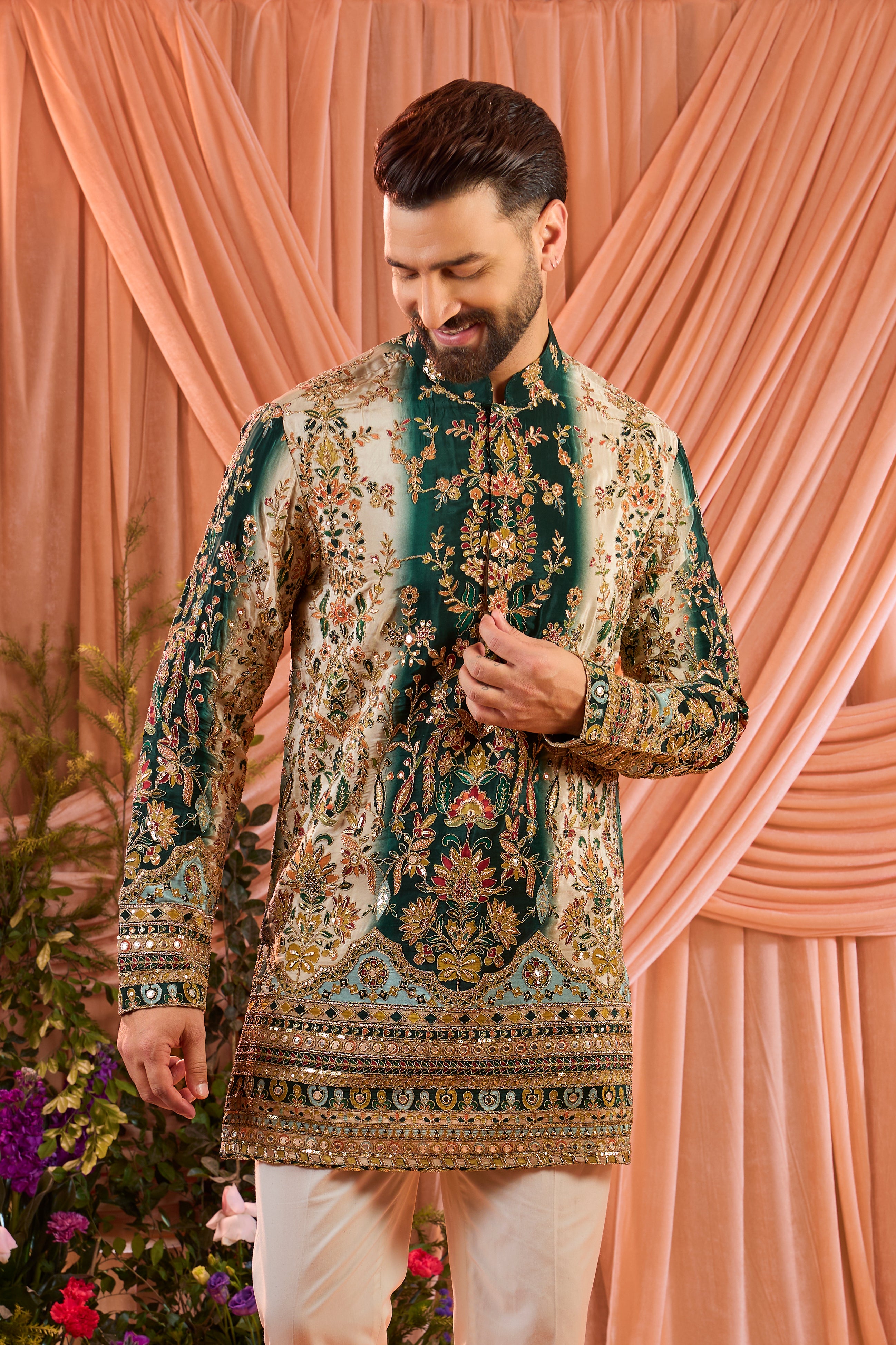 A green and gold short kurta adorned with detailed floral embroidery and shimmering sequin accents