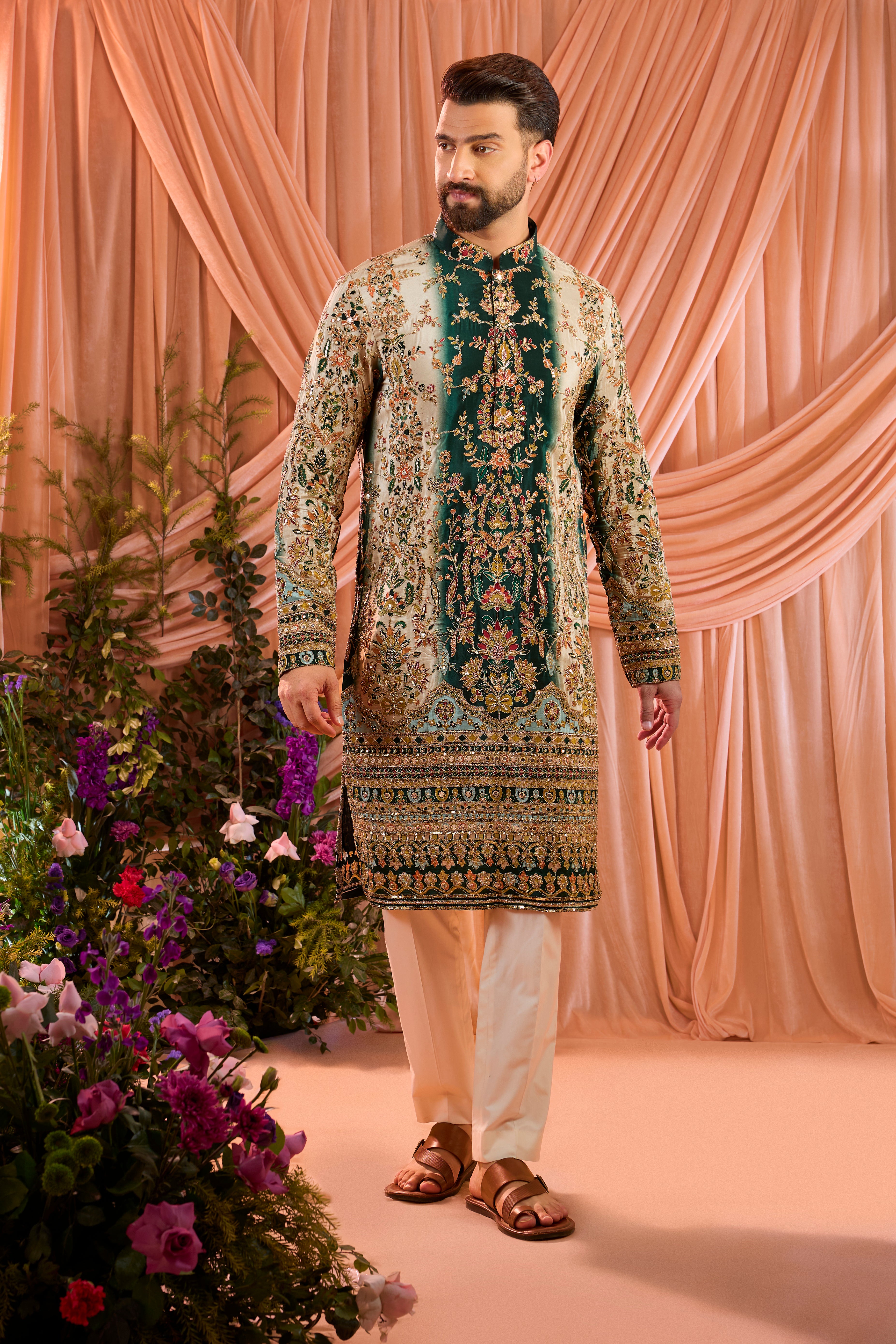 A green and gold kurta adorned with detailed floral embroidery and shimmering sequin accents.