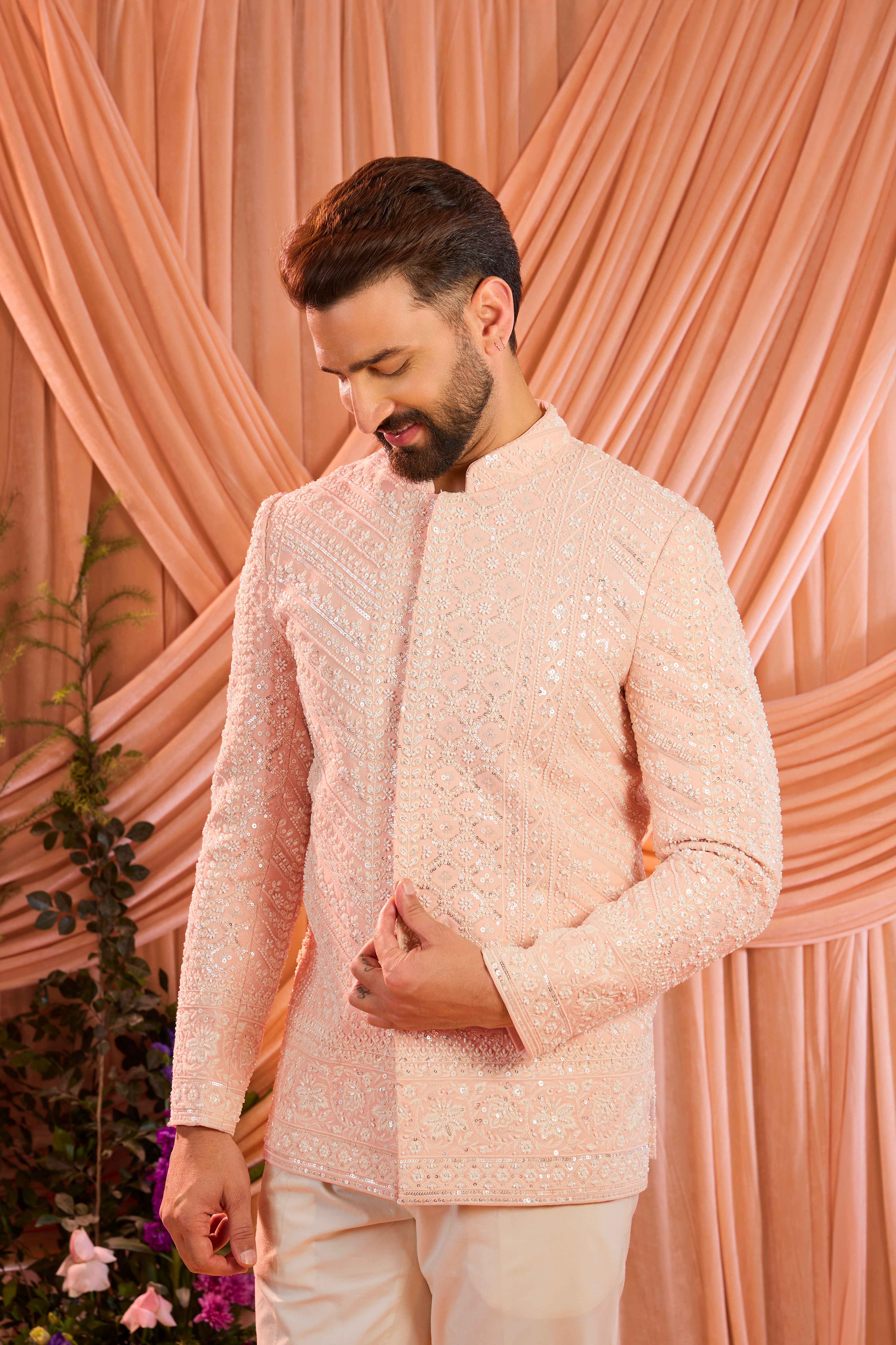 Pink hand-embroidered formal jacket , exquisitely adorned with intricate ivory cut-dana detailing. The refined shimmer and precision craftsmanship evoke understated opulence and modern royalty.