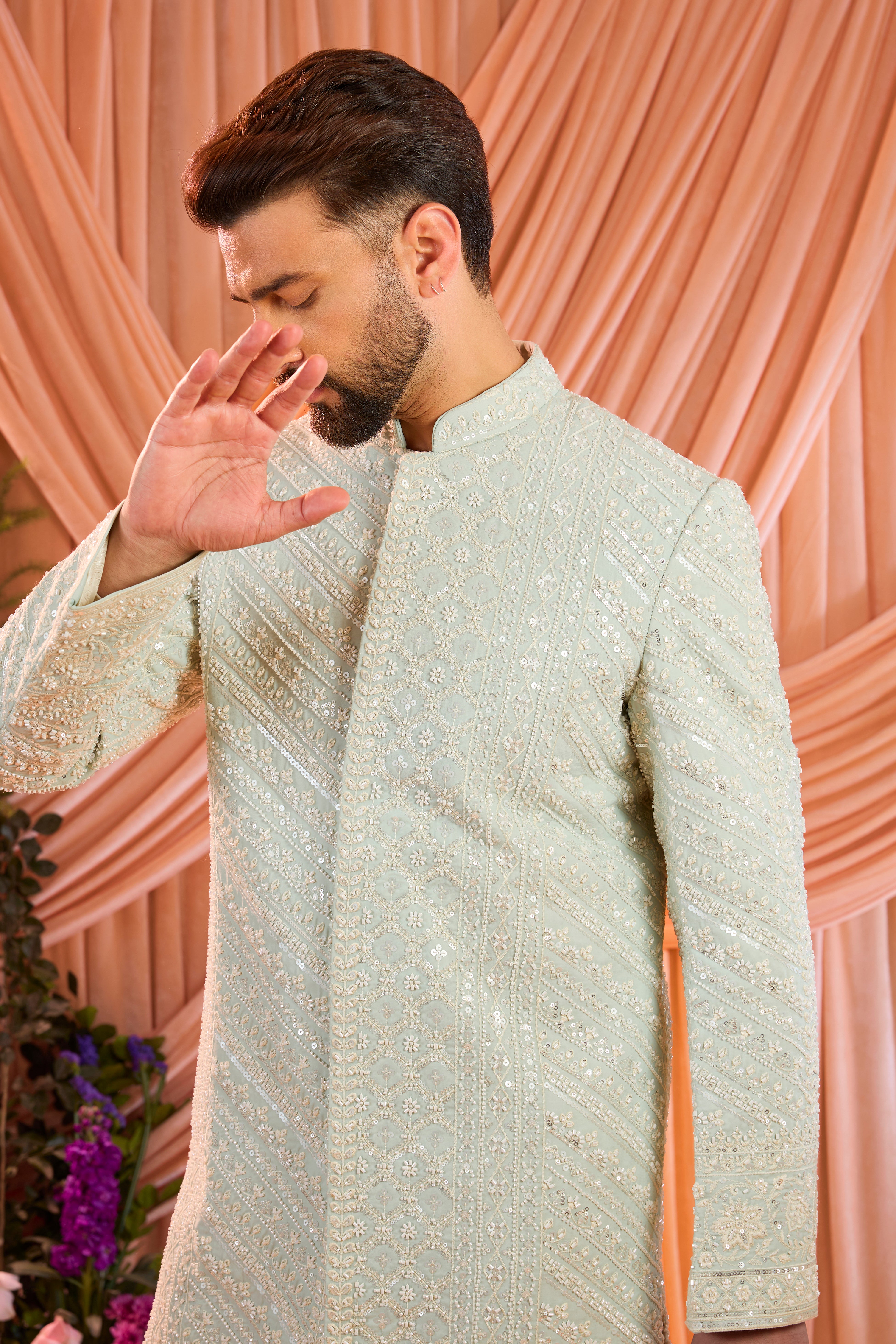 An aqua blue hand-embroidered formal sherwani, exquisitely adorned with intricate ivory cut-dana detailing