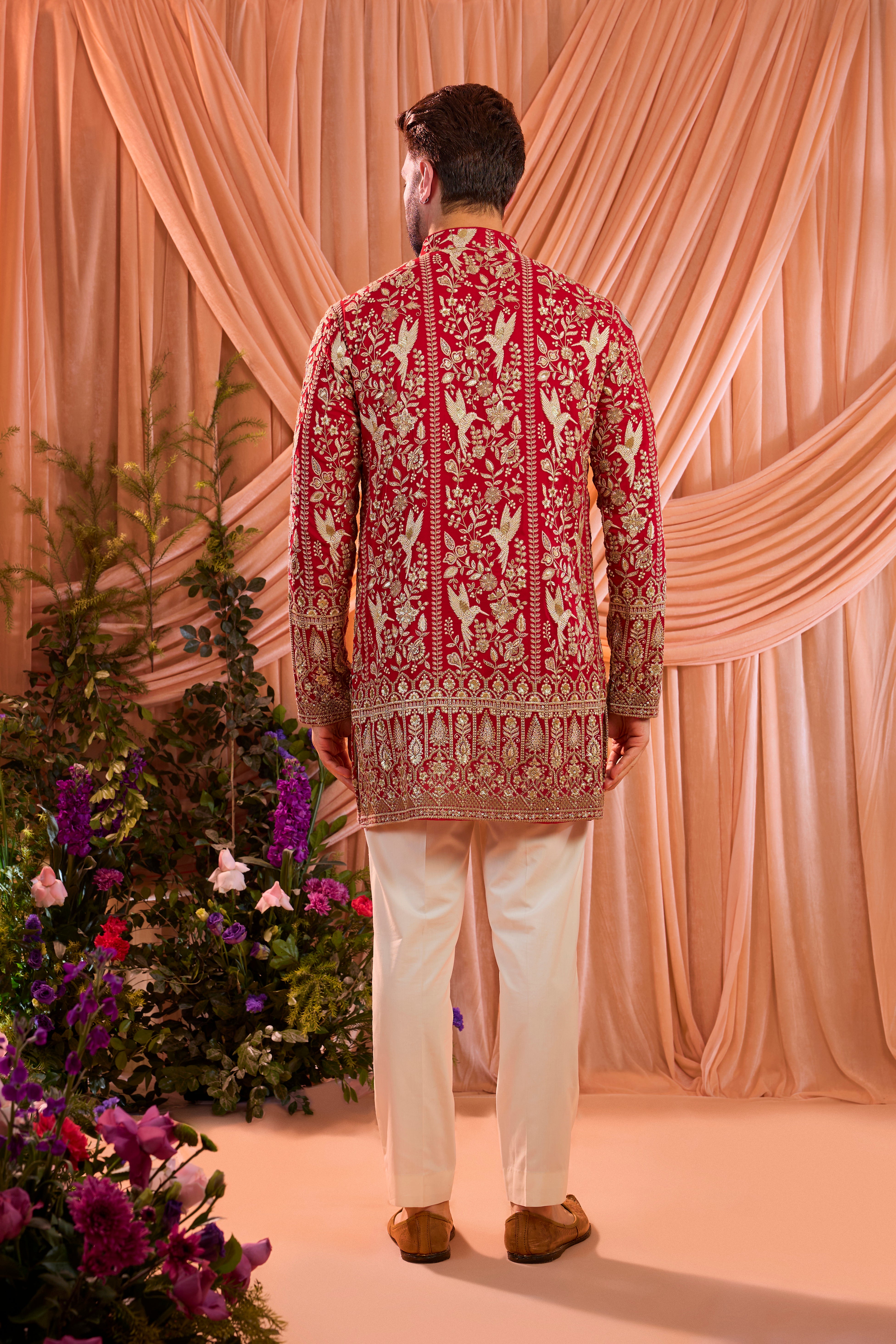 A hot pink short chikankari kurta adorned with intricate flora and fauna motifs, reflecting refined artisanal craftsmanship.