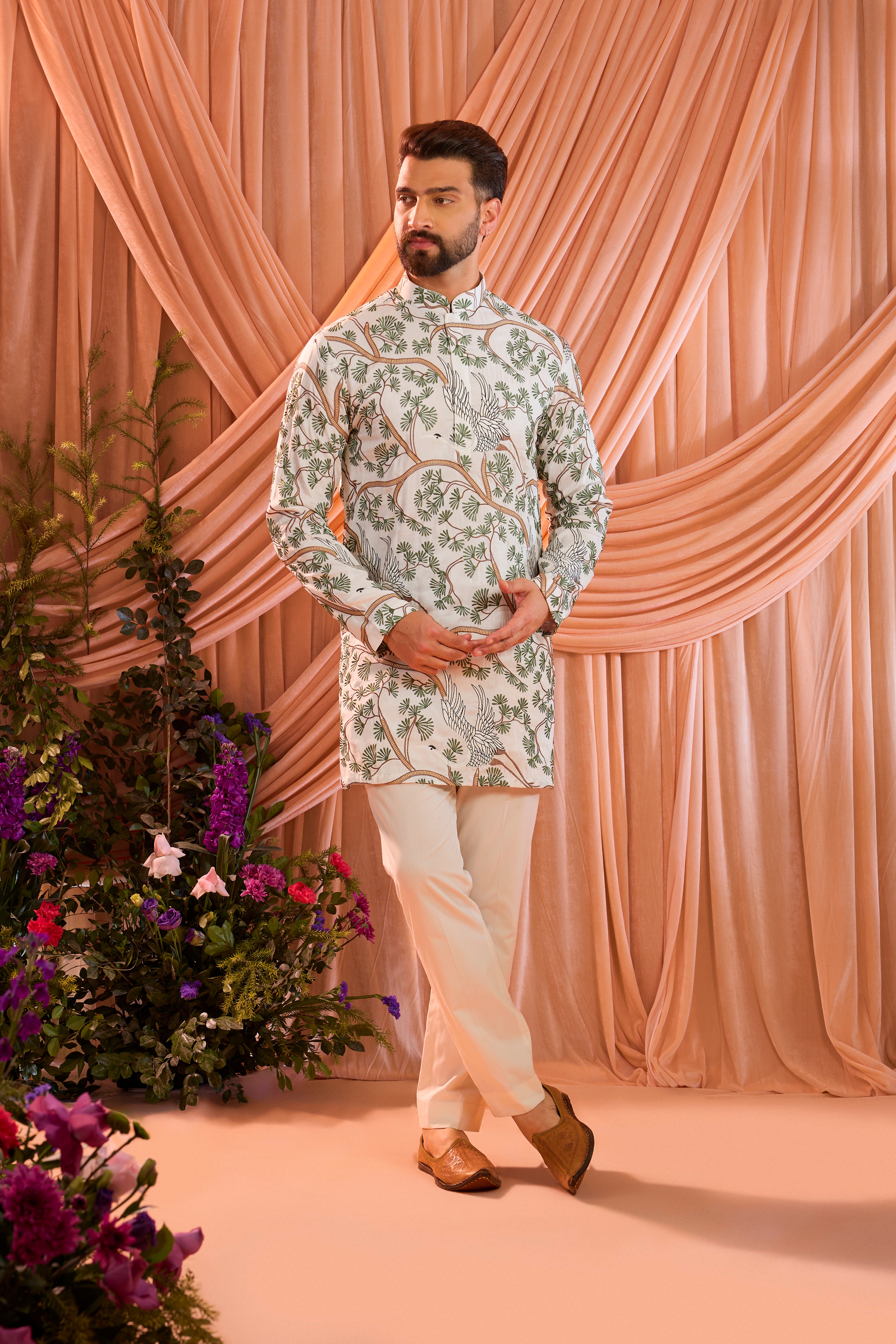 An ivory short kurta featuring a beautifully rendered tropical backdrop, highlighted by serene flamingo motifs.