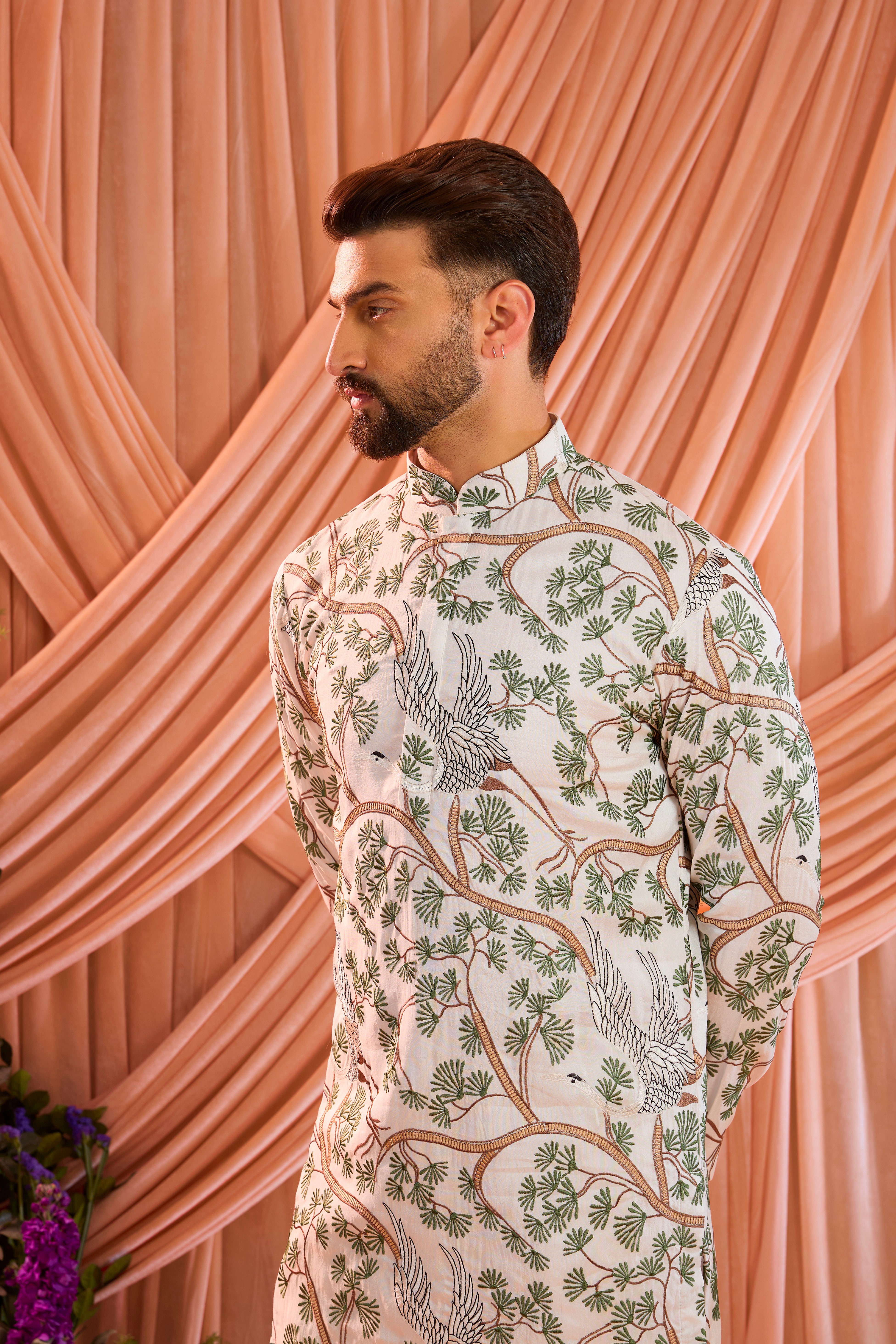 An ivory short kurta featuring a beautifully rendered tropical backdrop, highlighted by serene flamingo motifs.