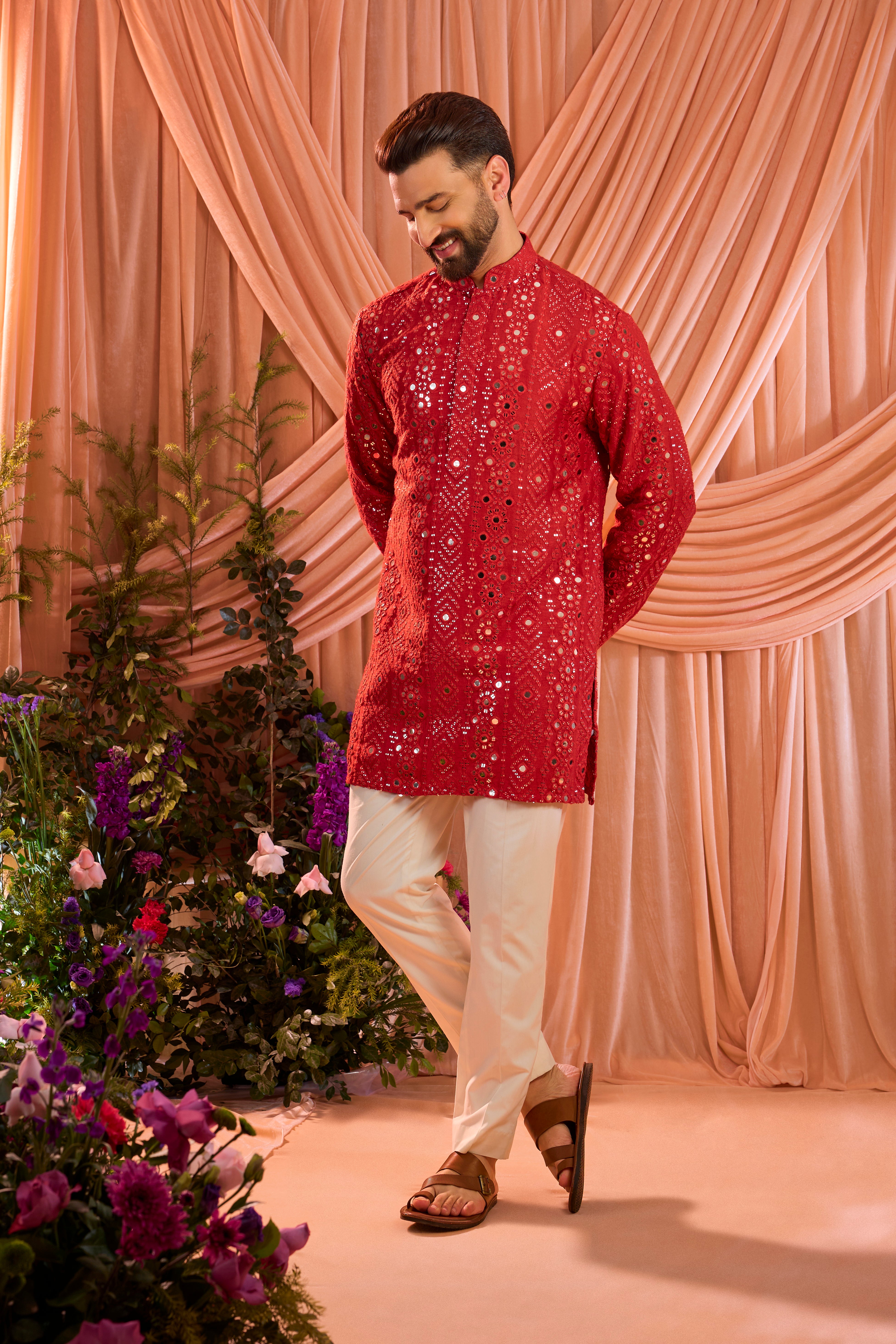 A signature red short kurta featuring mirror-inspired sequin work that recreates the brilliance of traditional mirror craftsmanship.