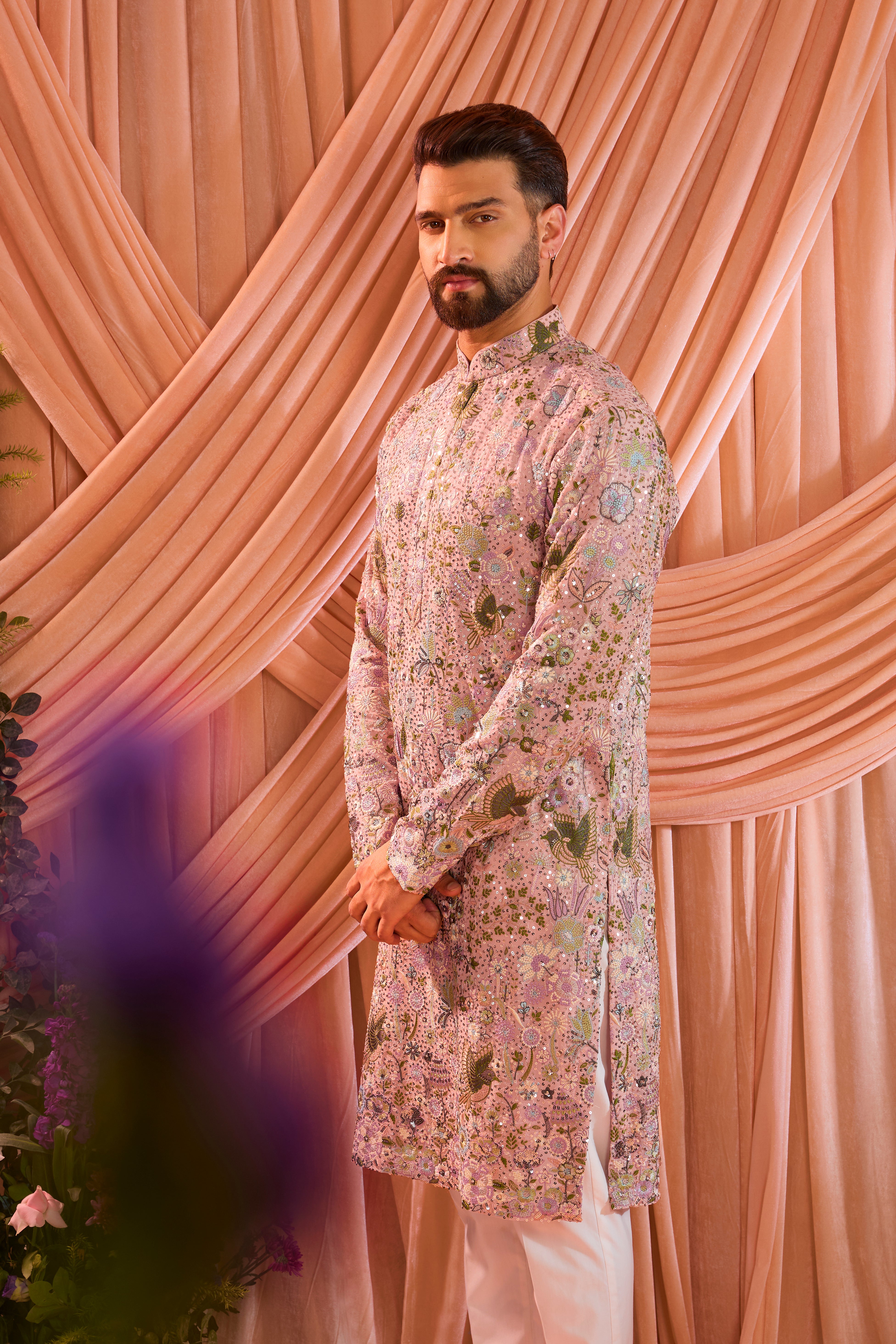 A pink sequined kurta adorned with detailed flora and fauna motifs, brought to life through intricate multi-thread embroidery.