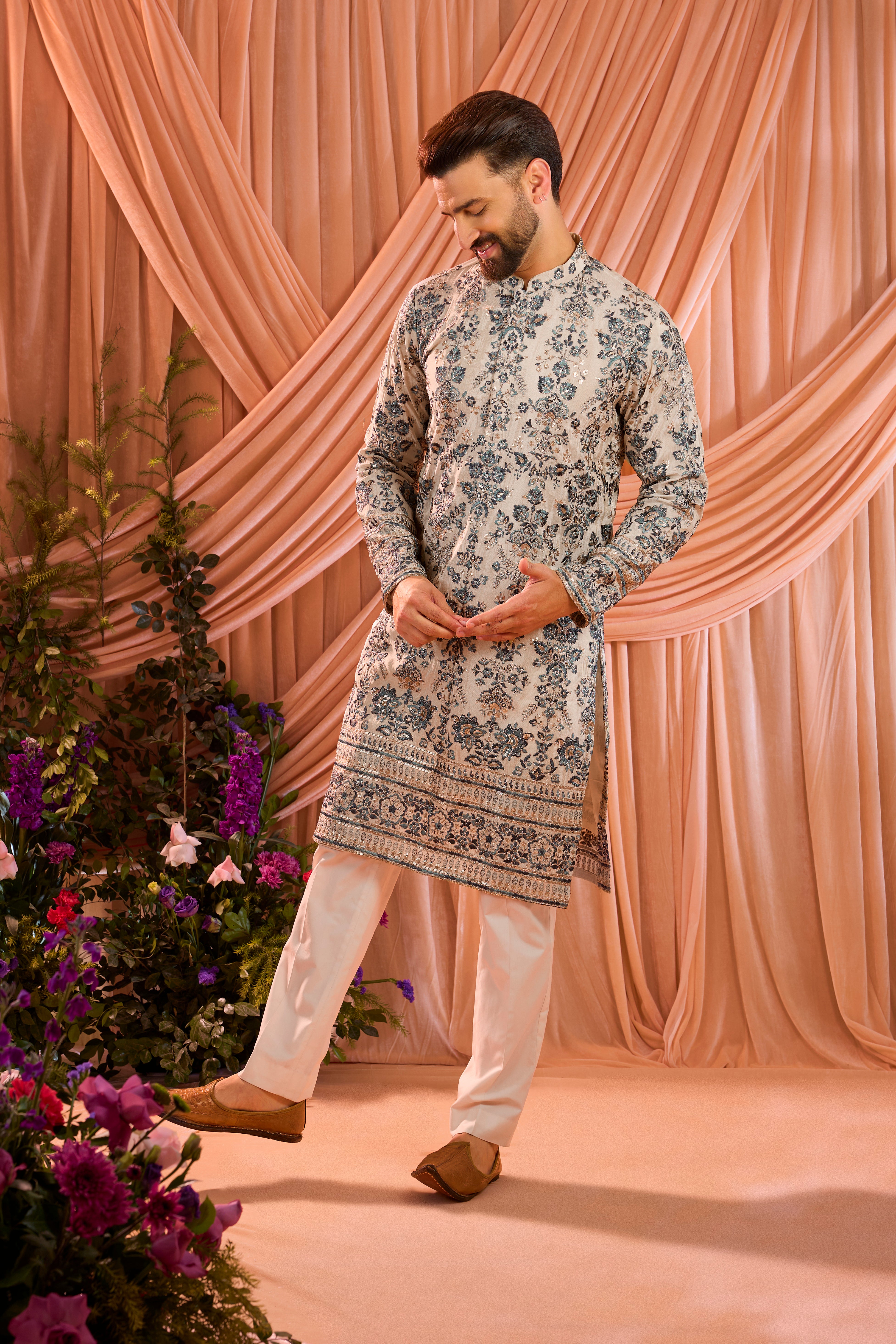 A light golden short floral chikankari kurta accented with delicate blue threadwork, enriched by zari and subtle sequin detailing.