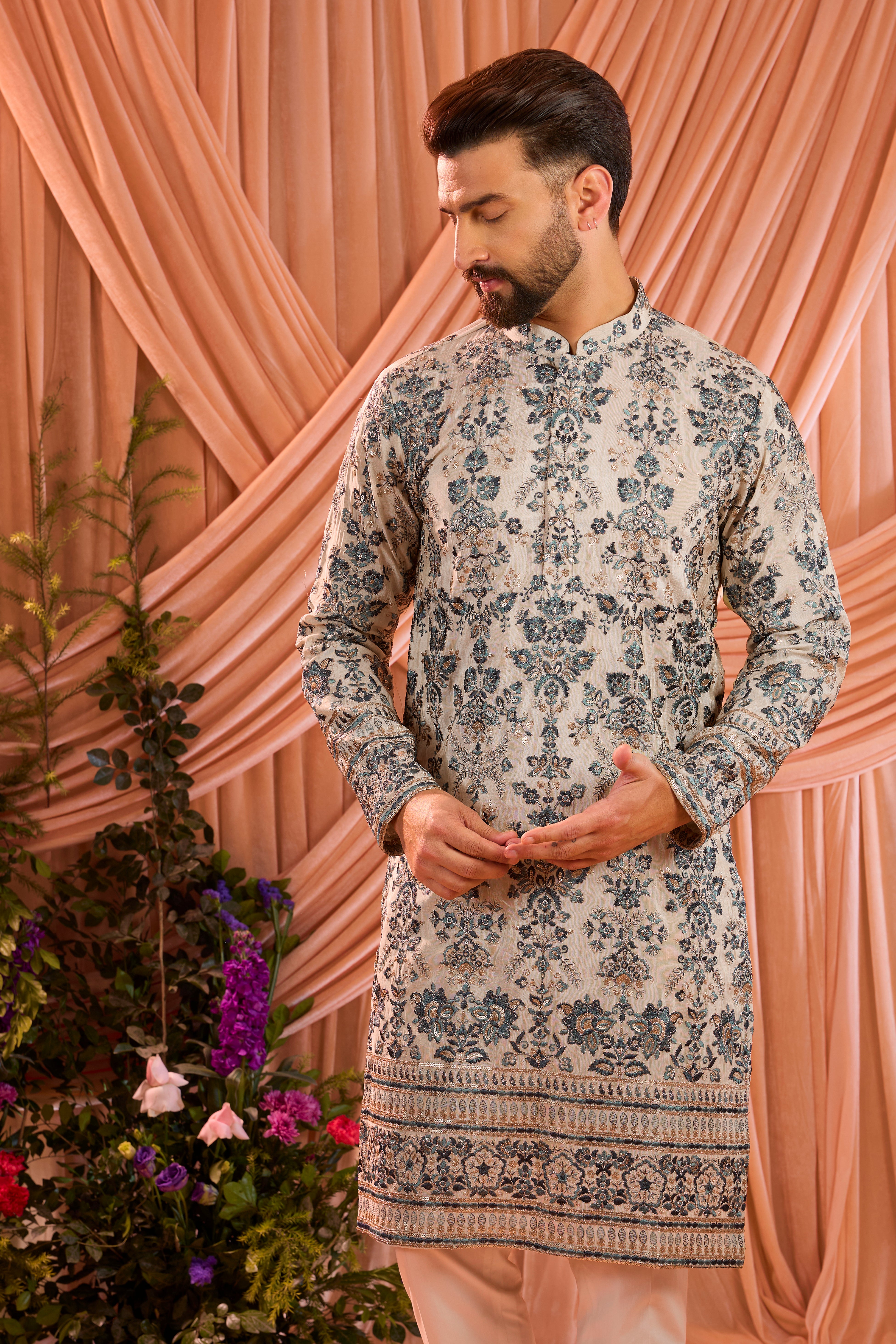A light golden short floral chikankari kurta accented with delicate blue threadwork, enriched by zari and subtle sequin detailing.