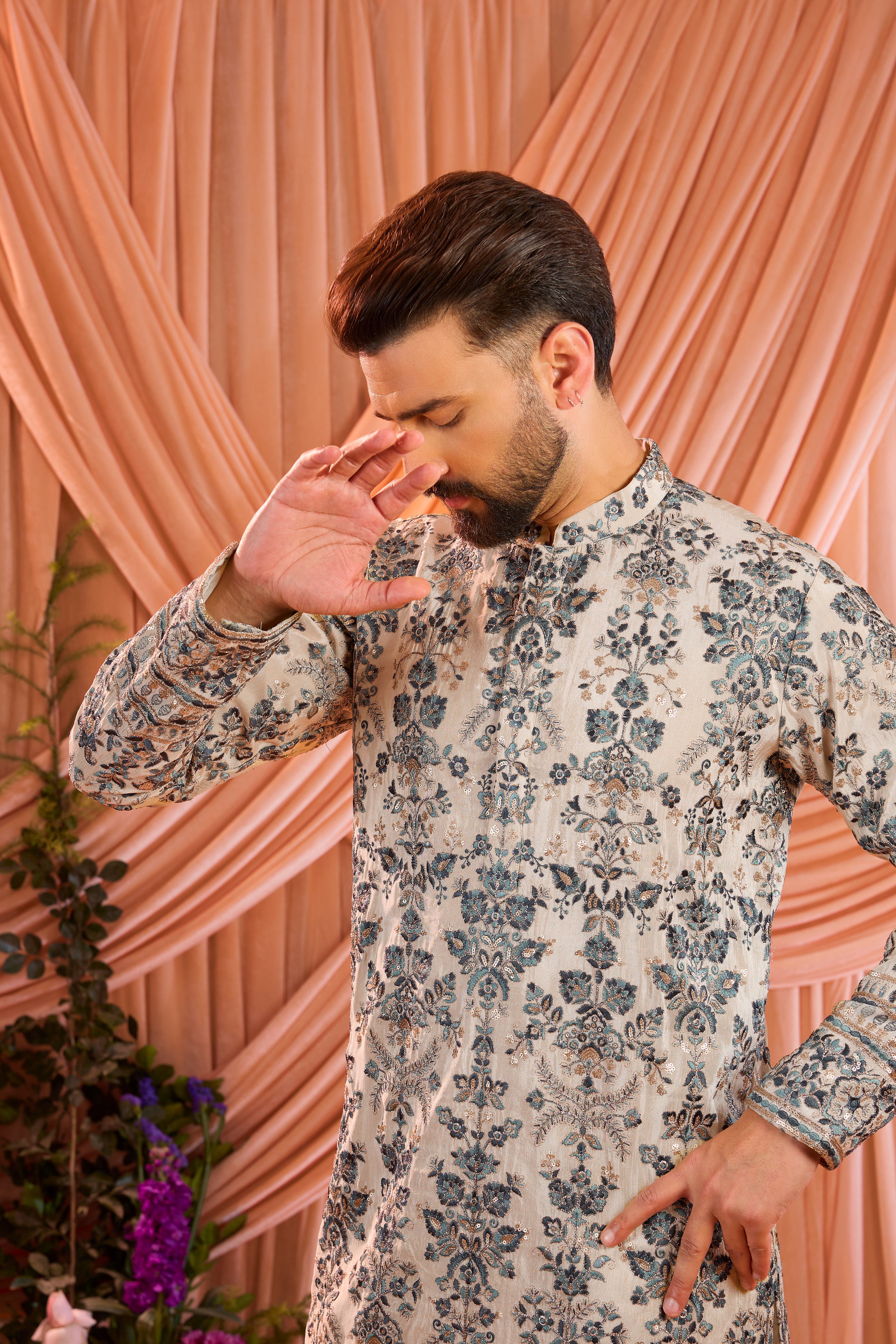 A light golden short floral chikankari kurta accented with delicate blue threadwork, enriched by zari and subtle sequin detailing.