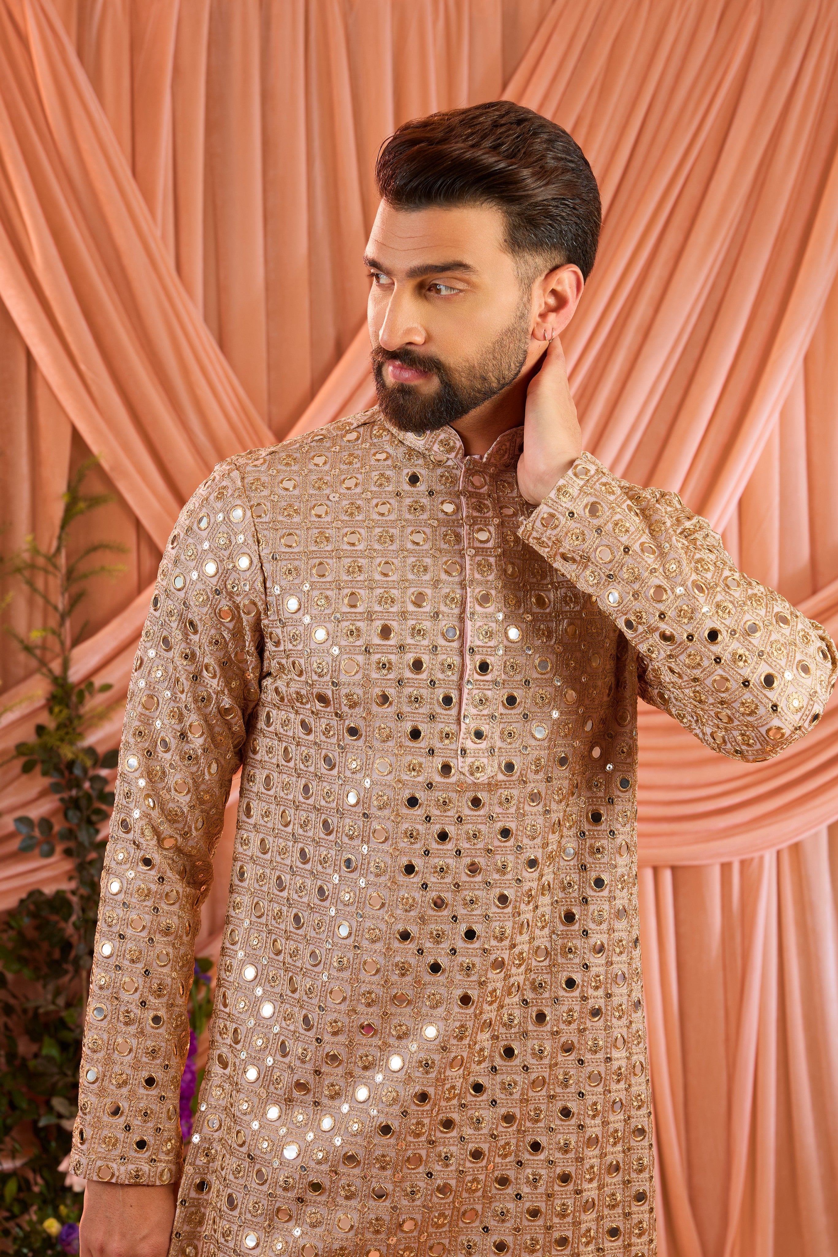 A pink short kurta featuring mirror-inspired sequin work that captures the brilliance of traditional mirror craftsmanship.