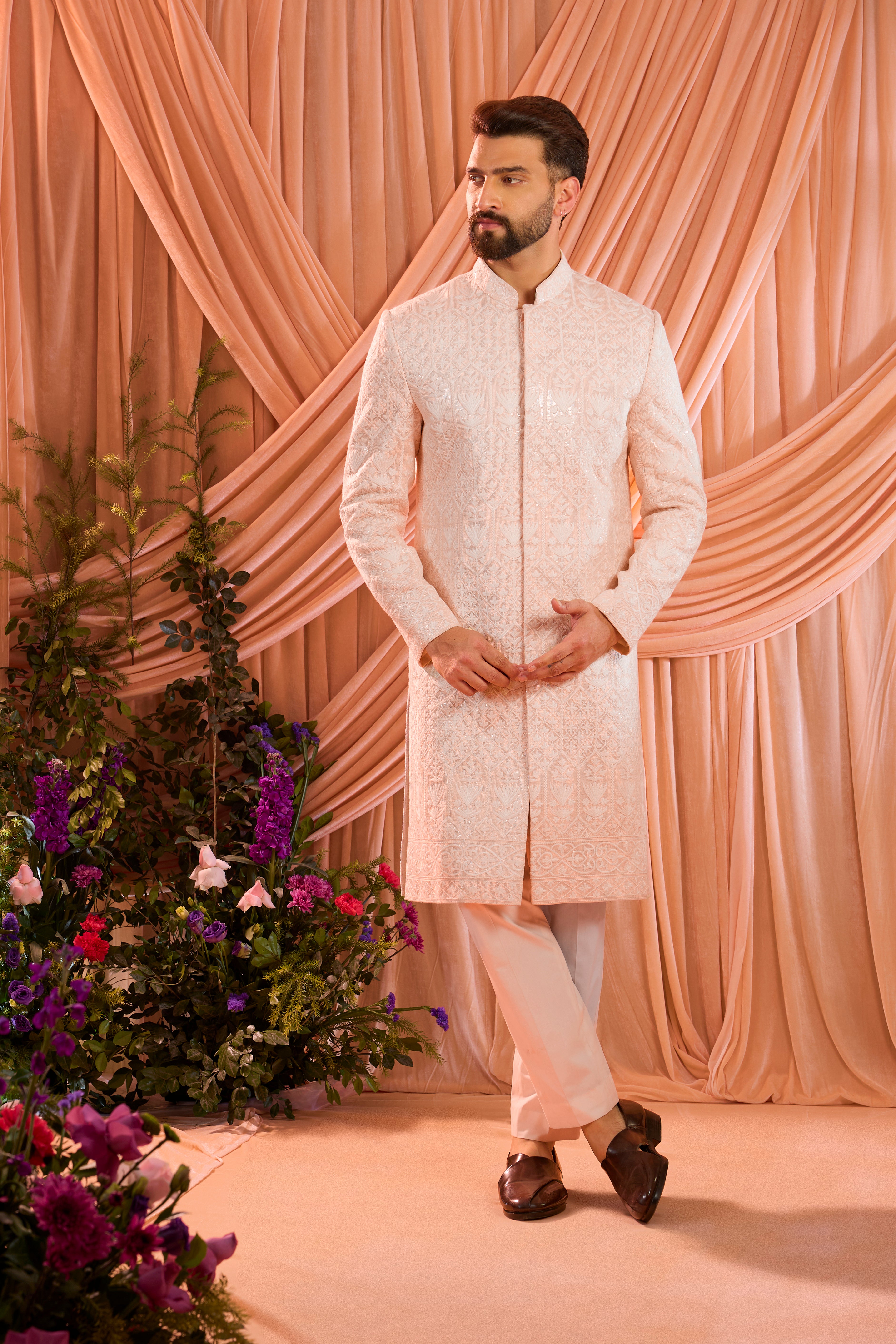 Pink chikankari sherwani distinguished by heavy ivory threadwork and meticulously detailed sequin embellishment