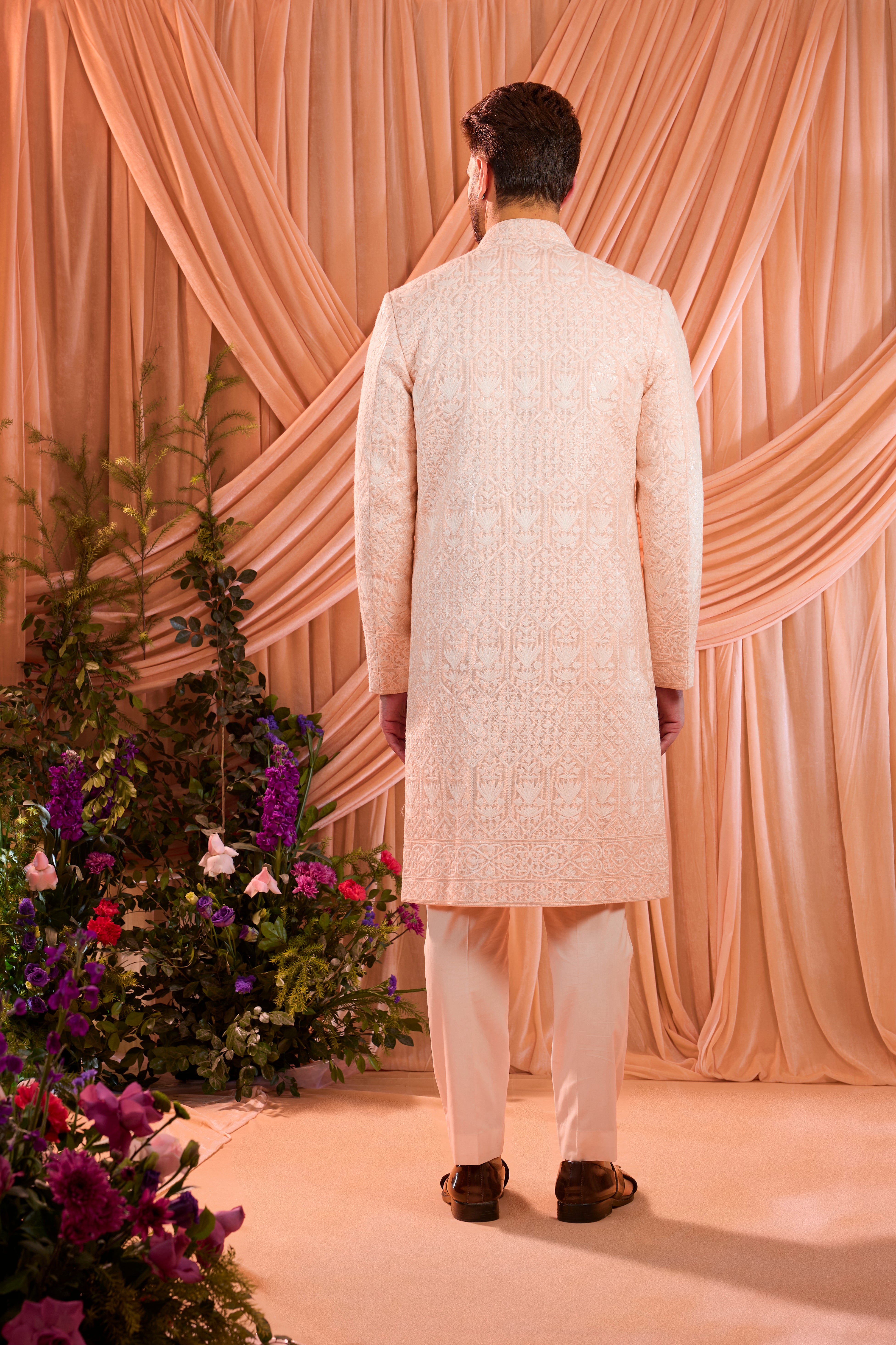 Pink chikankari sherwani distinguished by heavy ivory threadwork and meticulously detailed sequin embellishment