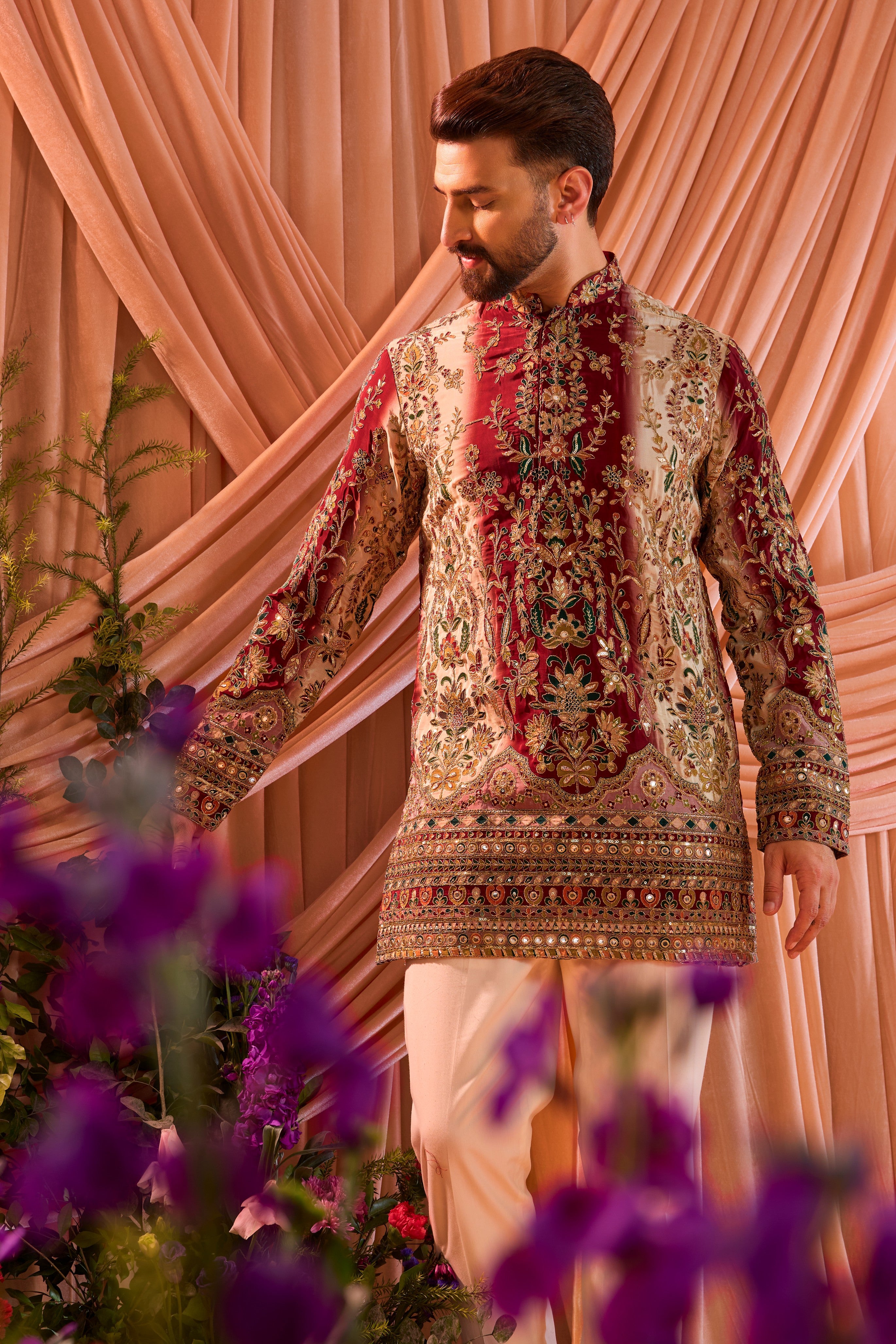 A green and gold short kurta adorned with detailed floral embroidery and shimmering sequin accents.