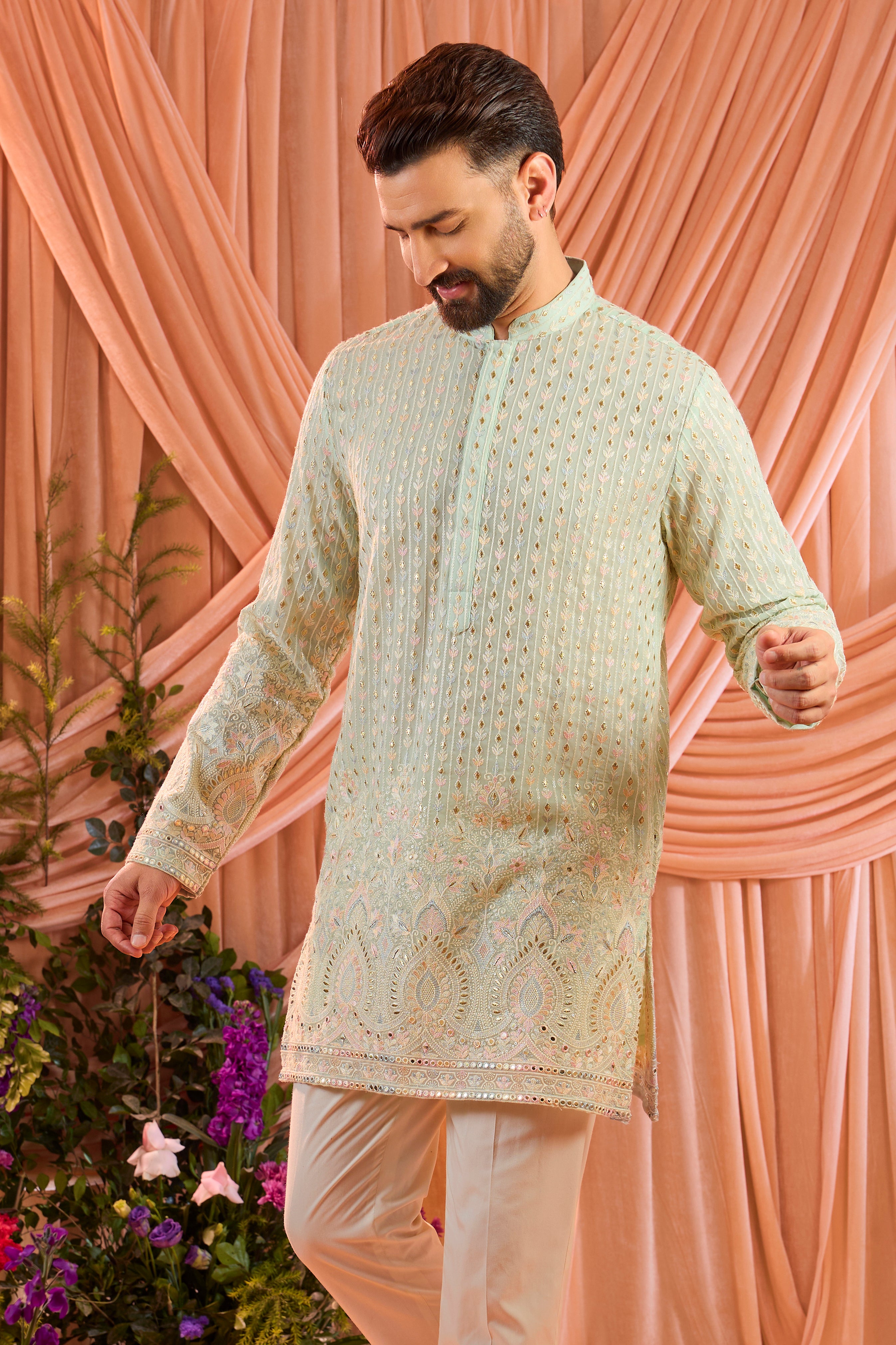 A aqua blue short kurta detailed with intricate multi-thread embroidery, enhanced by delicate sequins and subtle foil accents.