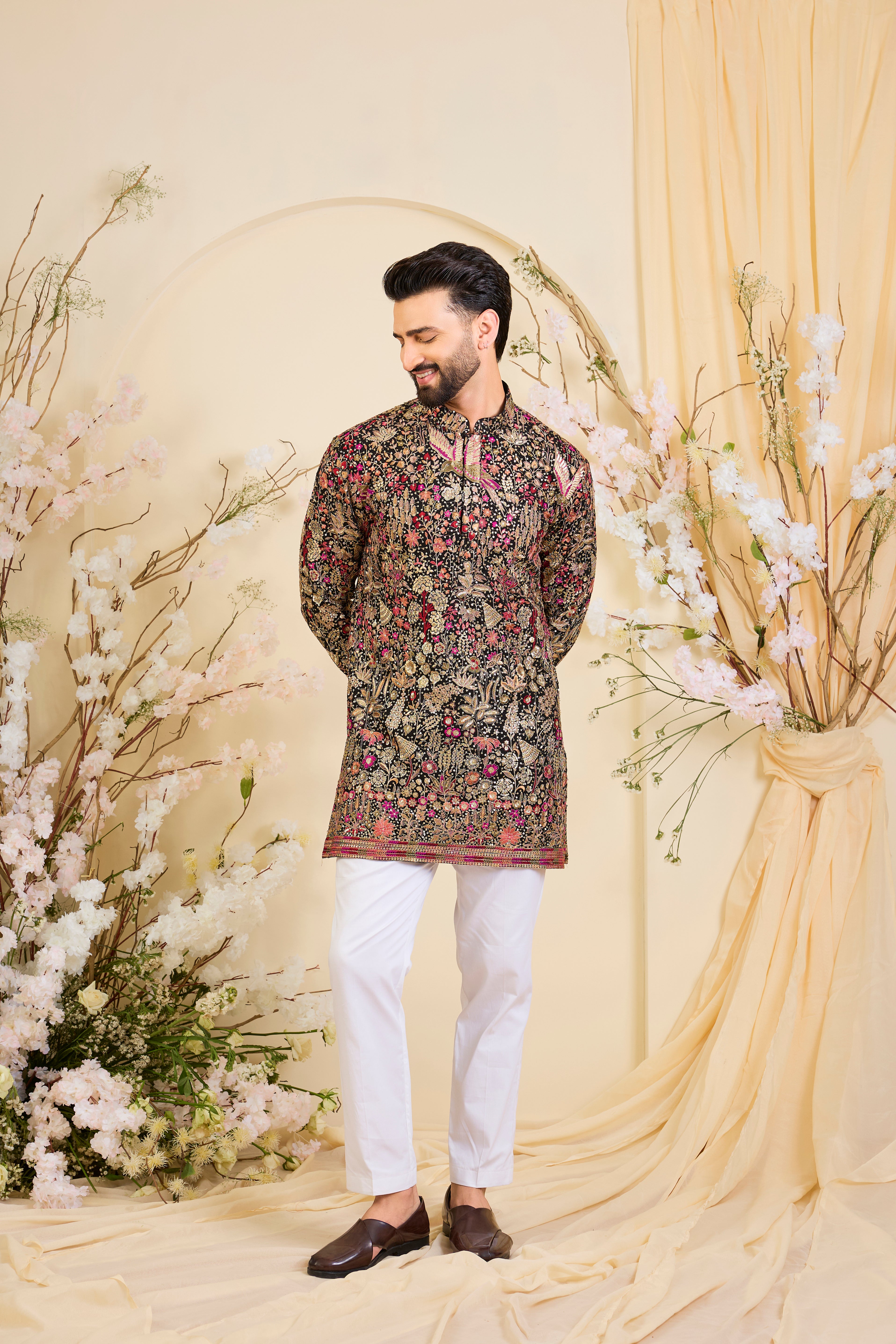 Black short kurta with intricate multicolour flora and fauna embroidery, elevated with zari accents and dense sequin detailing. A statement in formal luxury.