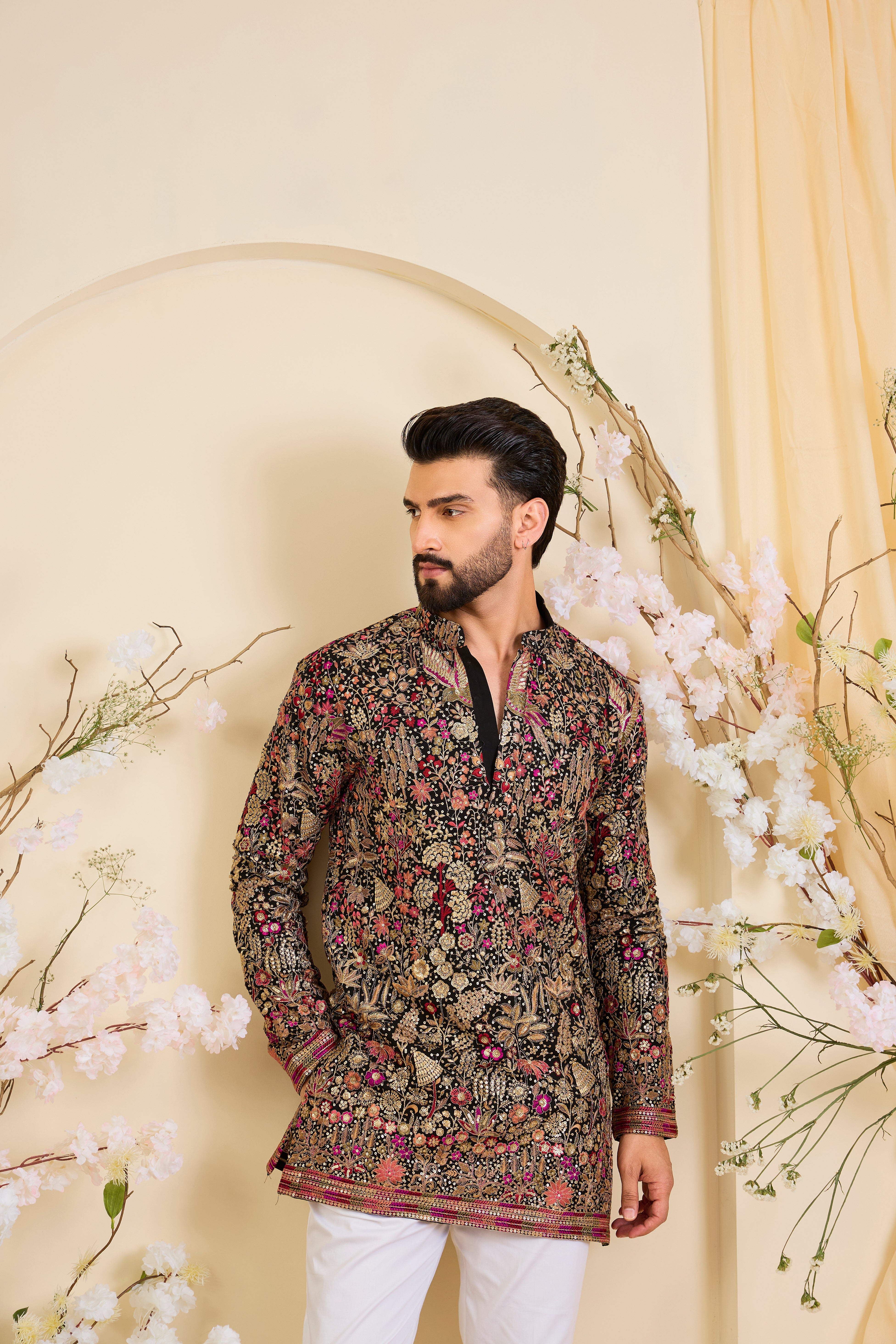 Black short kurta with intricate multicolour flora and fauna embroidery, elevated with zari accents and dense sequin detailing. A statement in formal luxury.