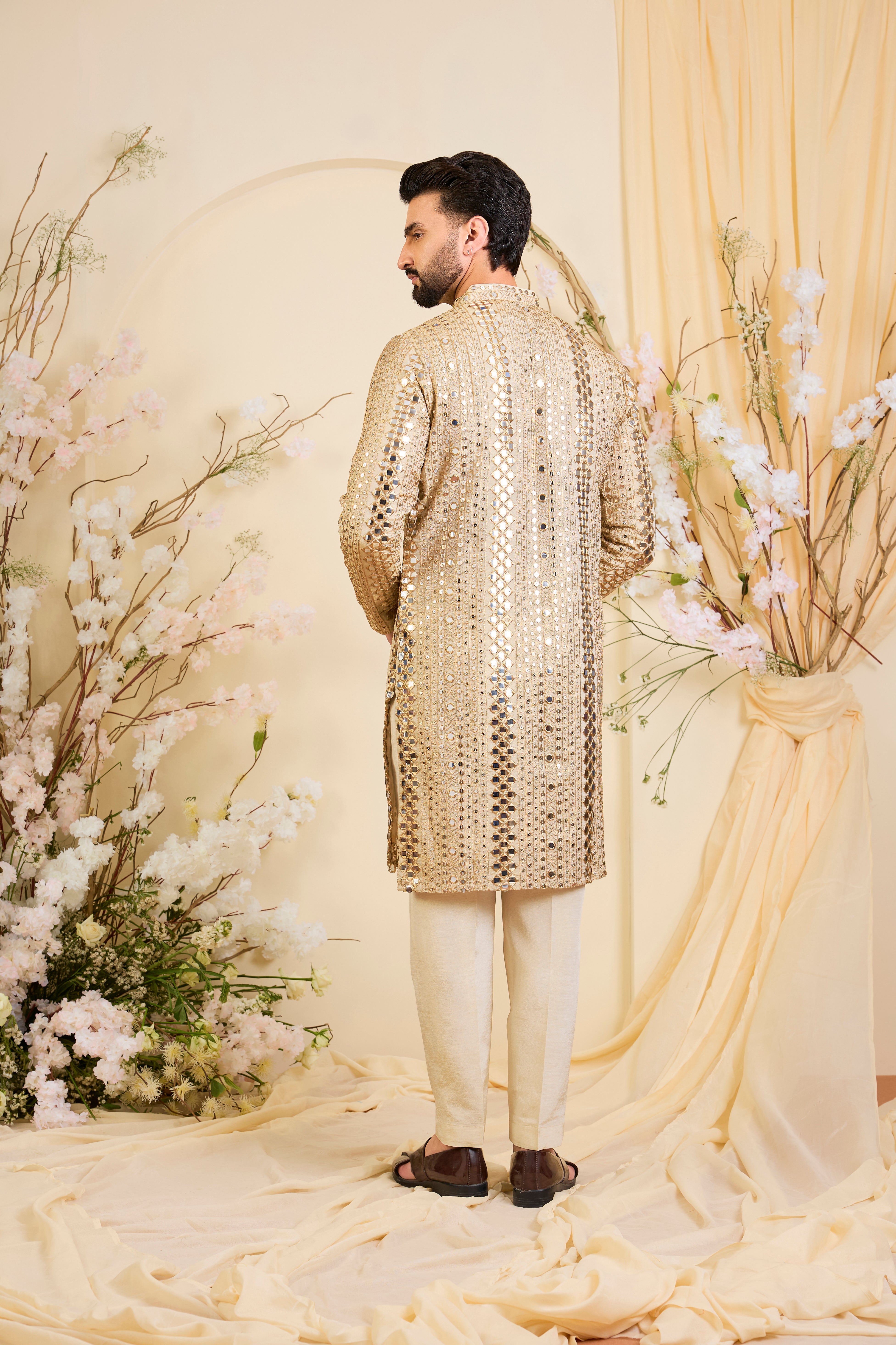 Golden tissue long kurta with intricate sequin mirrorwork and tone-on-tone threadwork. A luminous take on understated opulence.