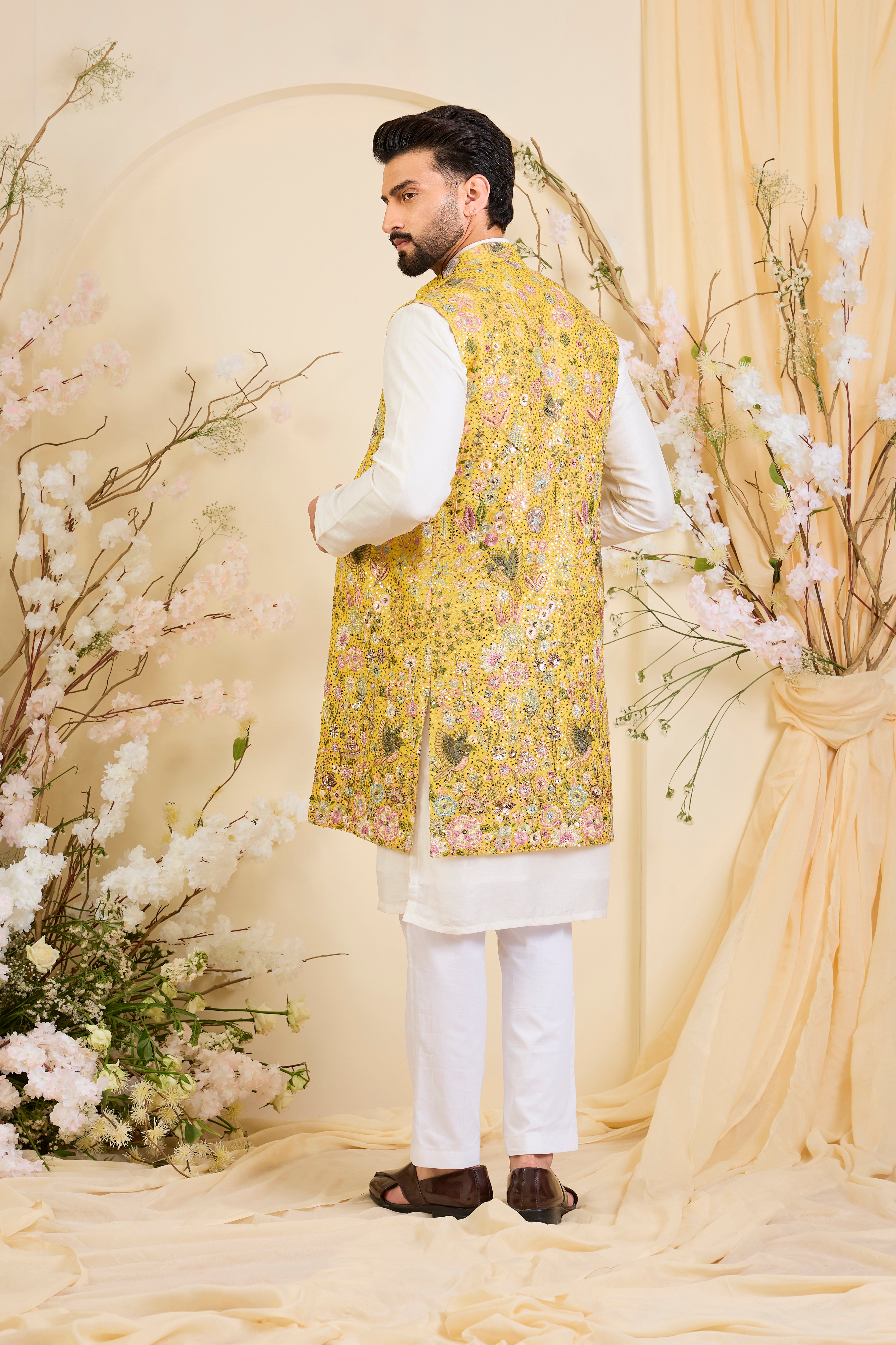 Yellow long open jacket with intricate sequin work and detailed flora-fauna motifs, offering a luminous, richly layered couture statement.