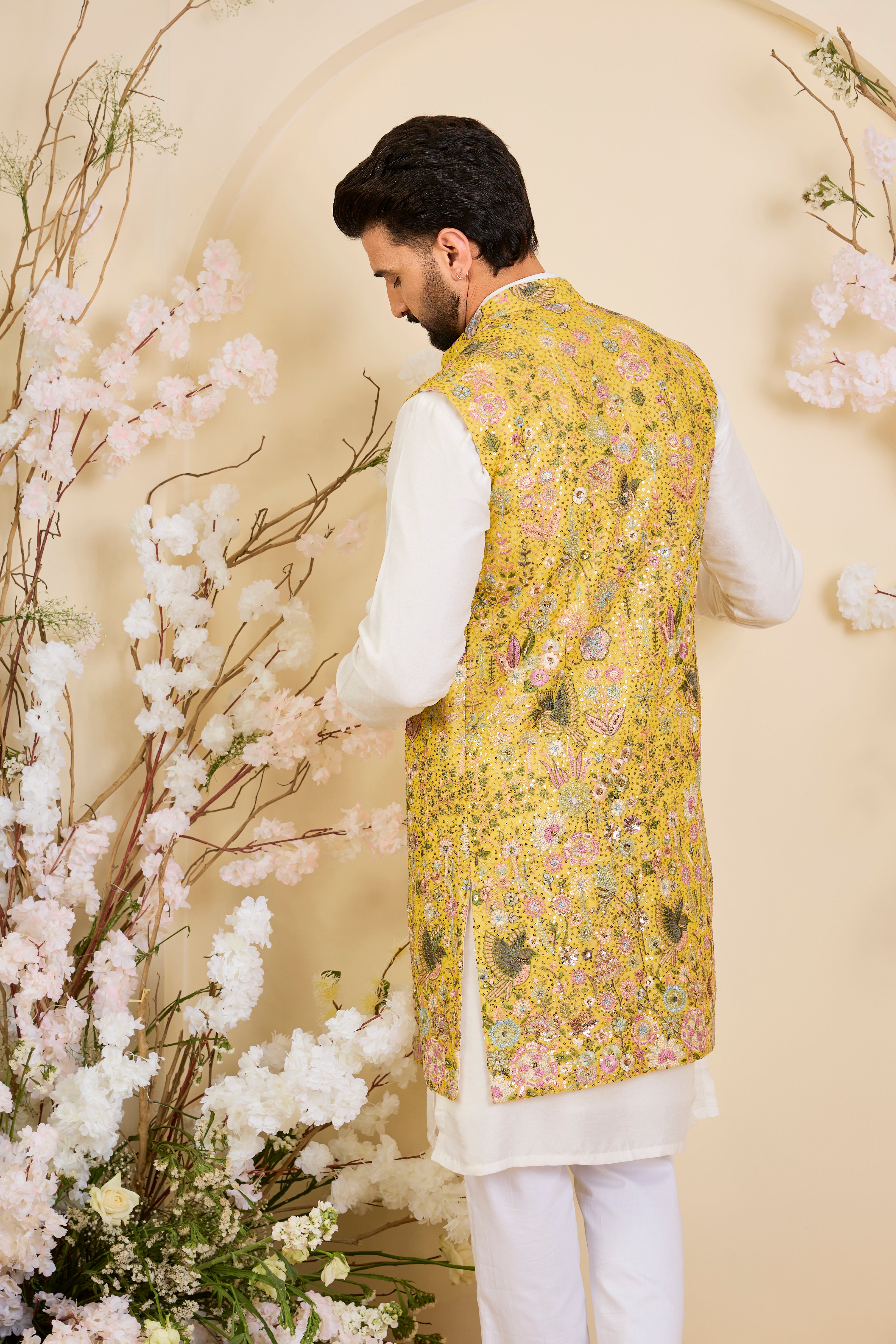 Yellow long open jacket with intricate sequin work and detailed flora-fauna motifs, offering a luminous, richly layered couture statement.
