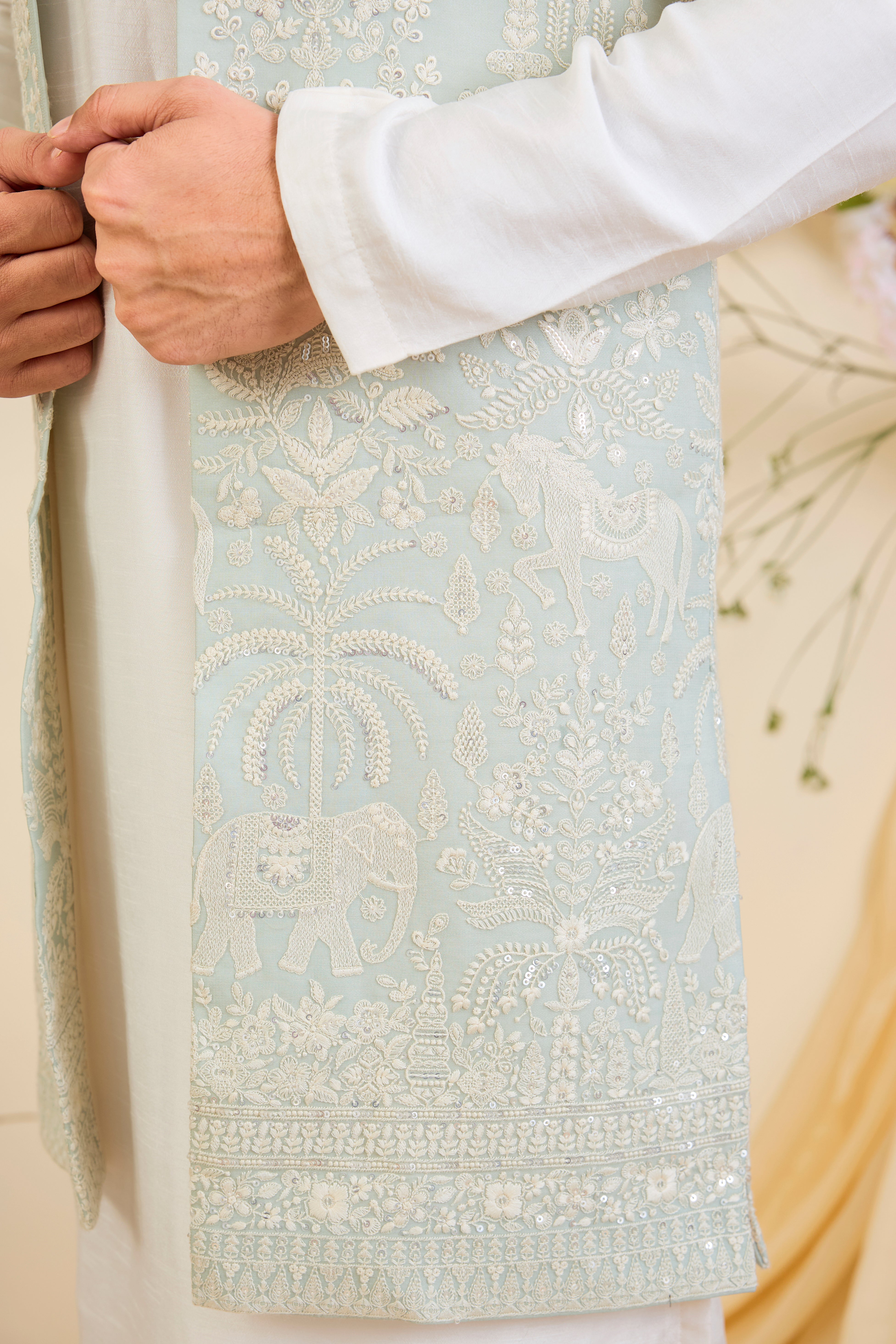 Blue sequined long jacket with ivory threadwork and intricate flora-fauna embroidery, crafted for luminous, refined, statement-making elegance.