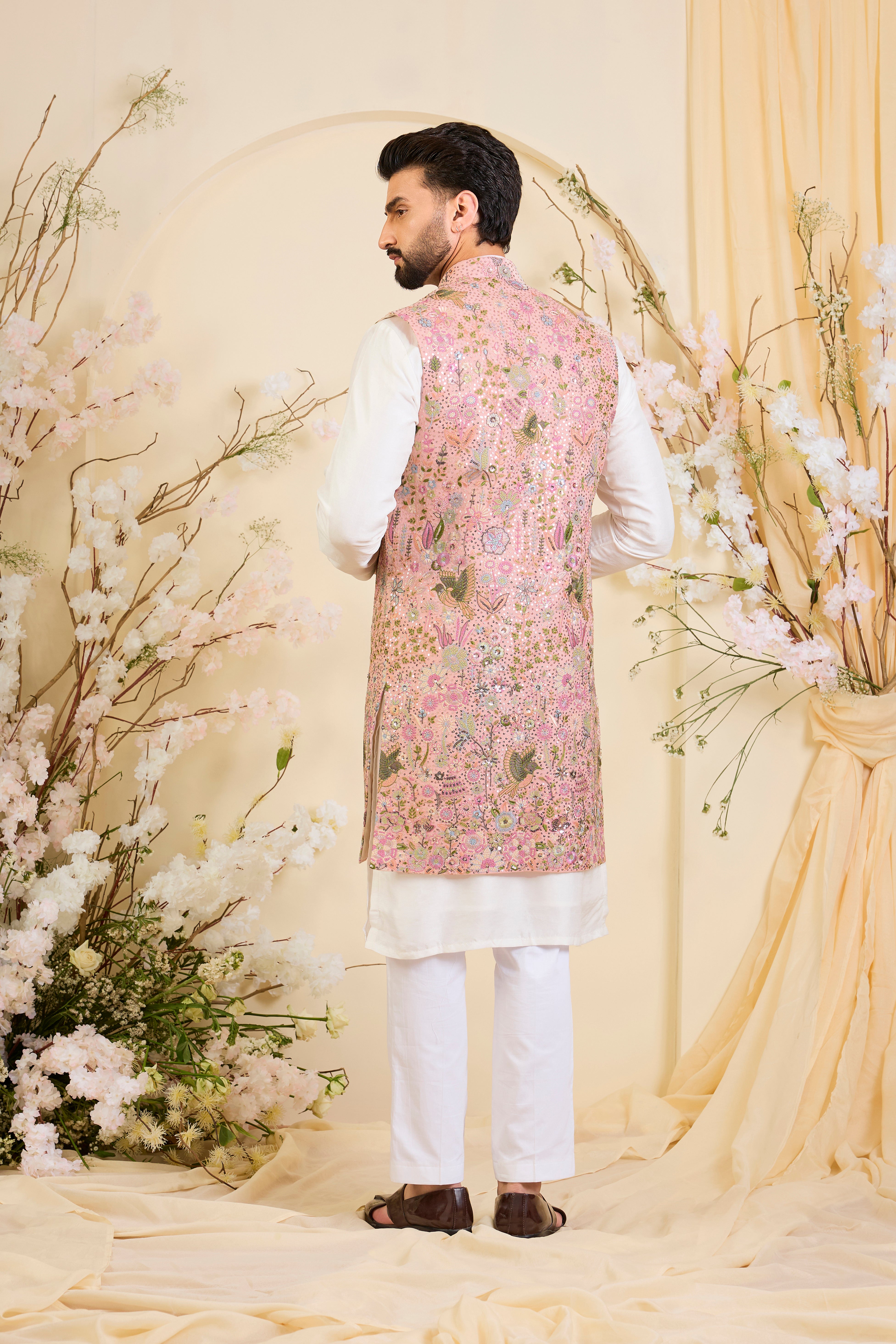 Pink long open jacket with intricate sequin work and detailed flora-fauna motifs, offering a luminous, richly layered couture statement.