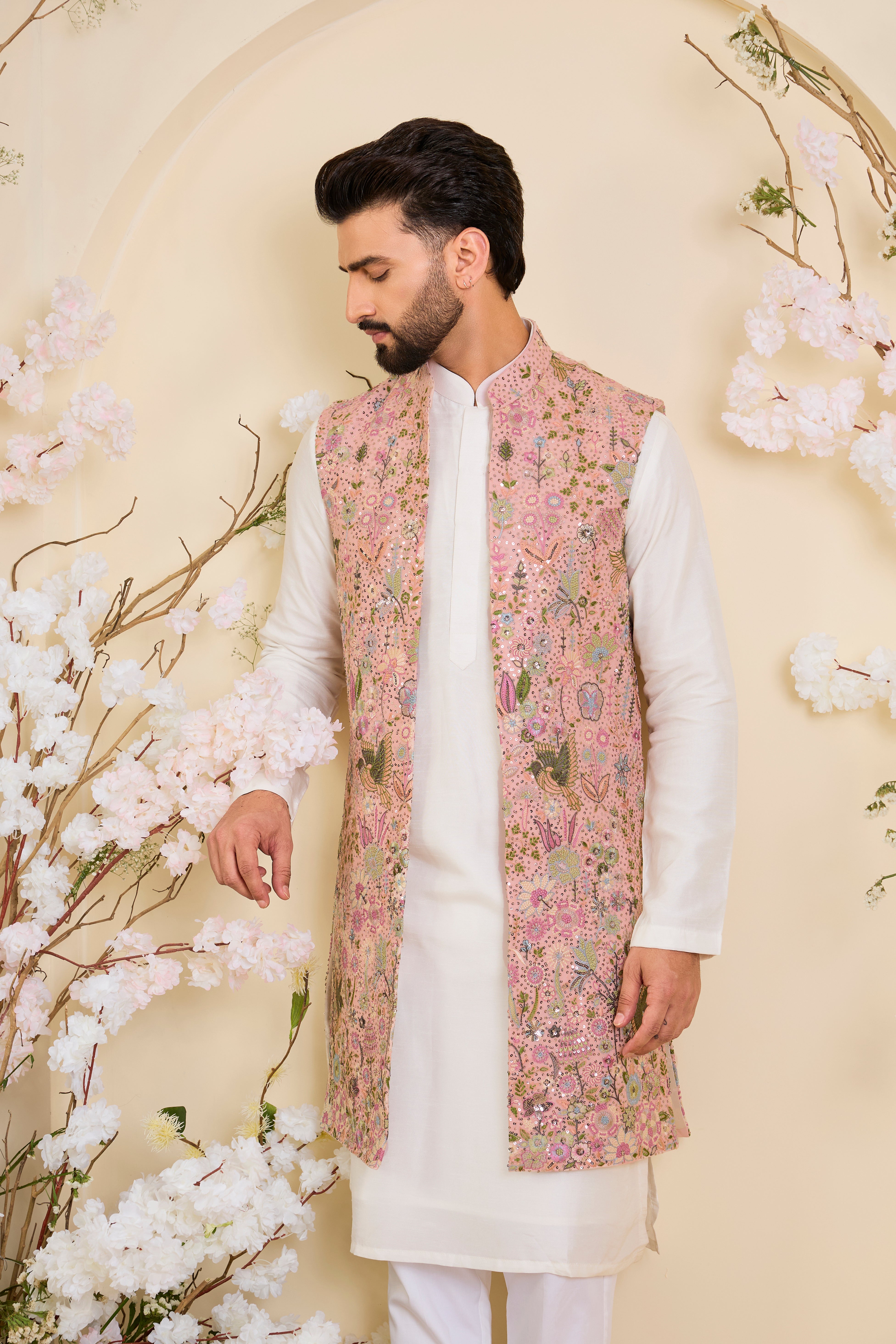 Pink long open jacket with intricate sequin work and detailed flora-fauna motifs, offering a luminous, richly layered couture statement.