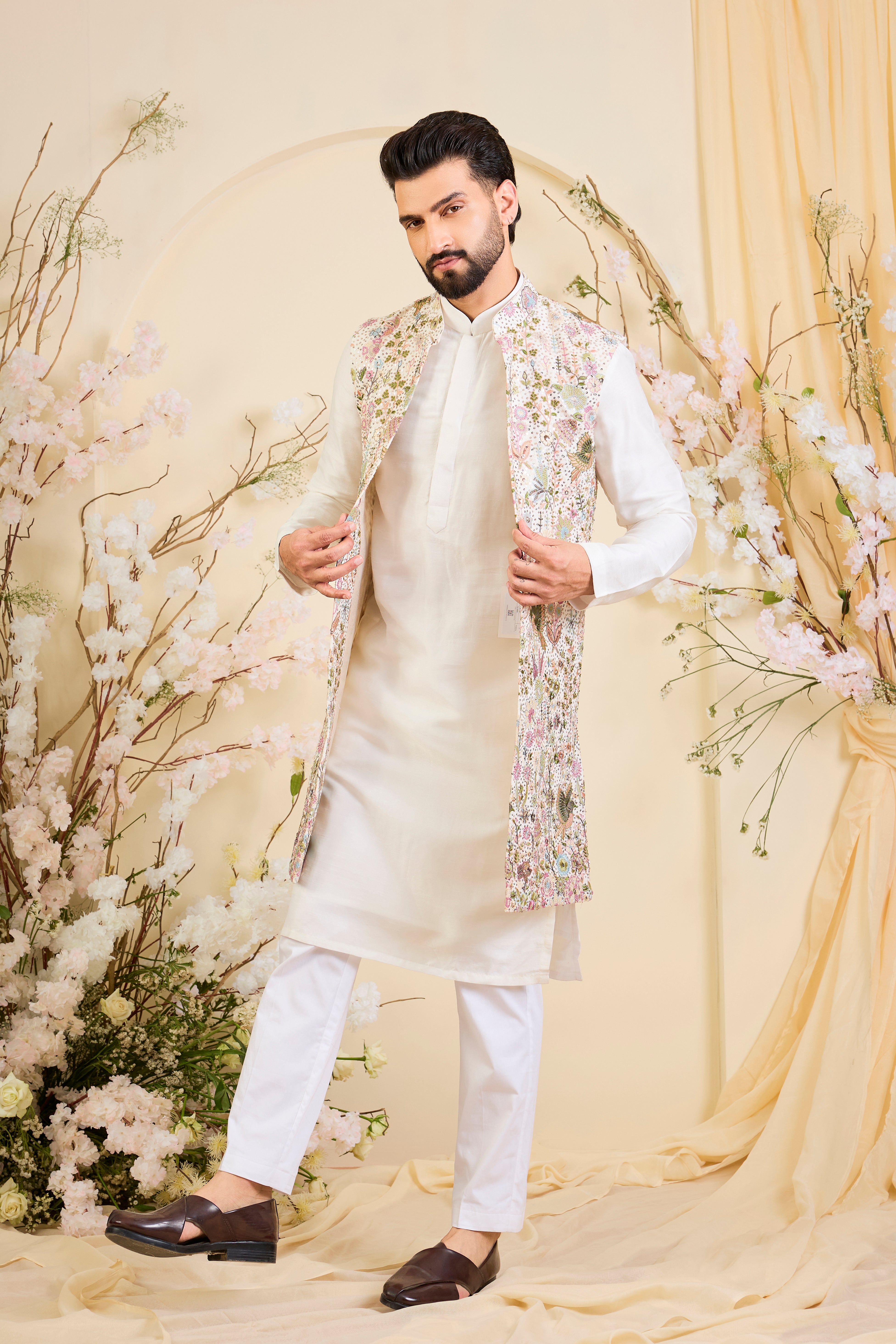 White long open jacket with intricate sequin work and detailed flora-fauna motifs, offering a luminous, richly layered couture statement.