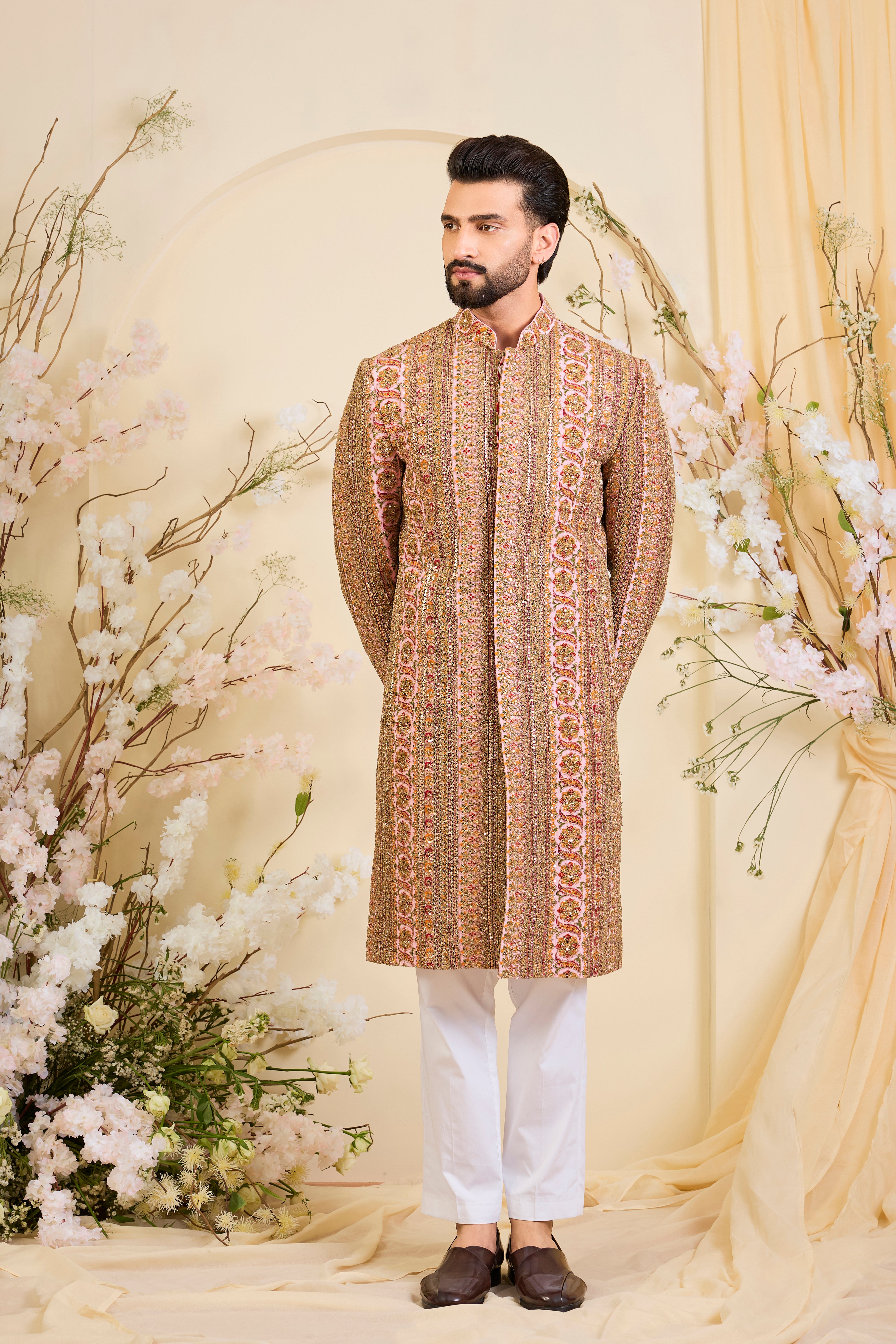 Pink base sherwani with heavy zari embroidery, intricate sequins, and multicolour prints, crafted for bold, opulent, statement-making occasions.