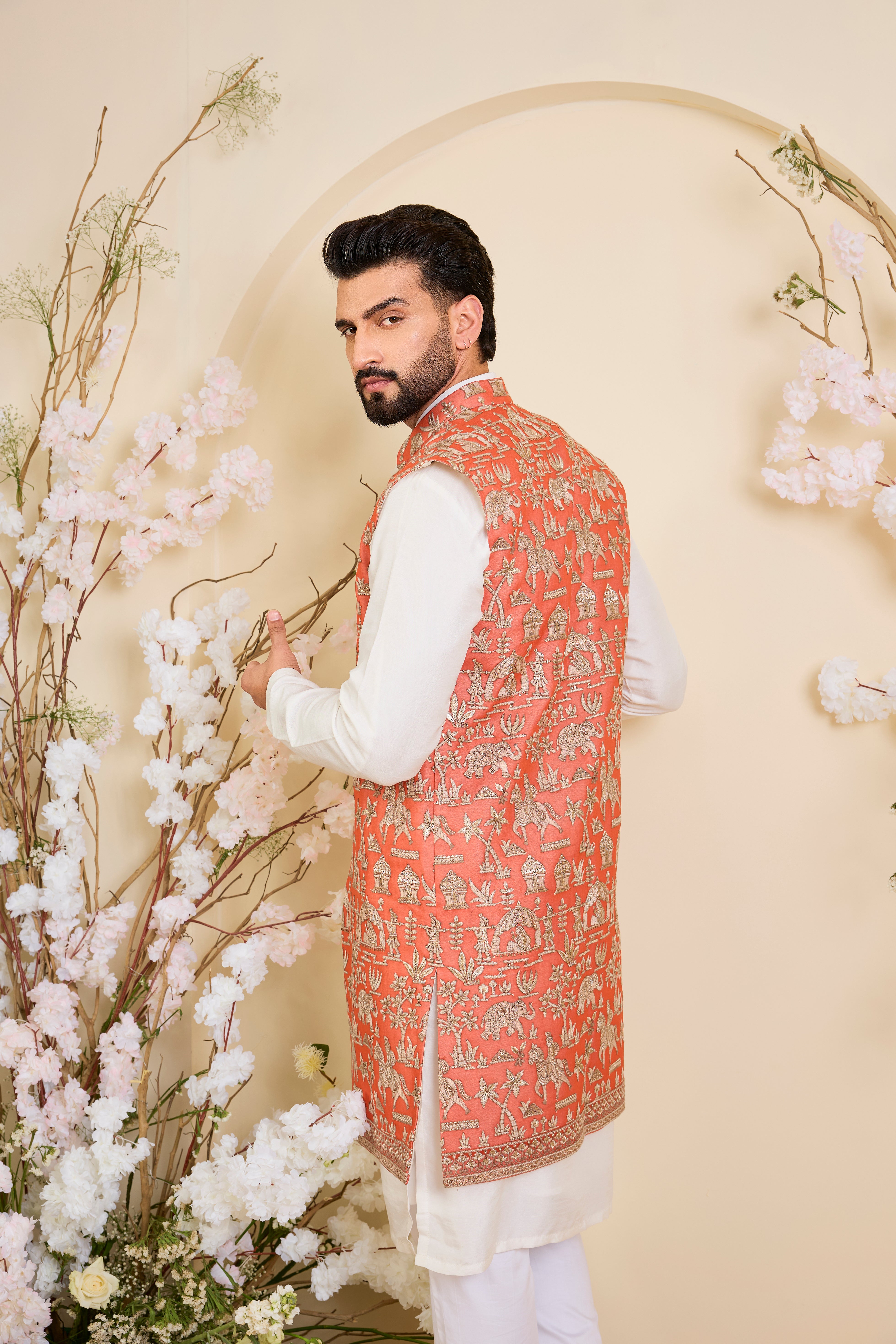 Orange long open jacket with intricate zari work, sequin detailing, and Mughal-era embroidery, delivering a richly layered, regal couture statement.