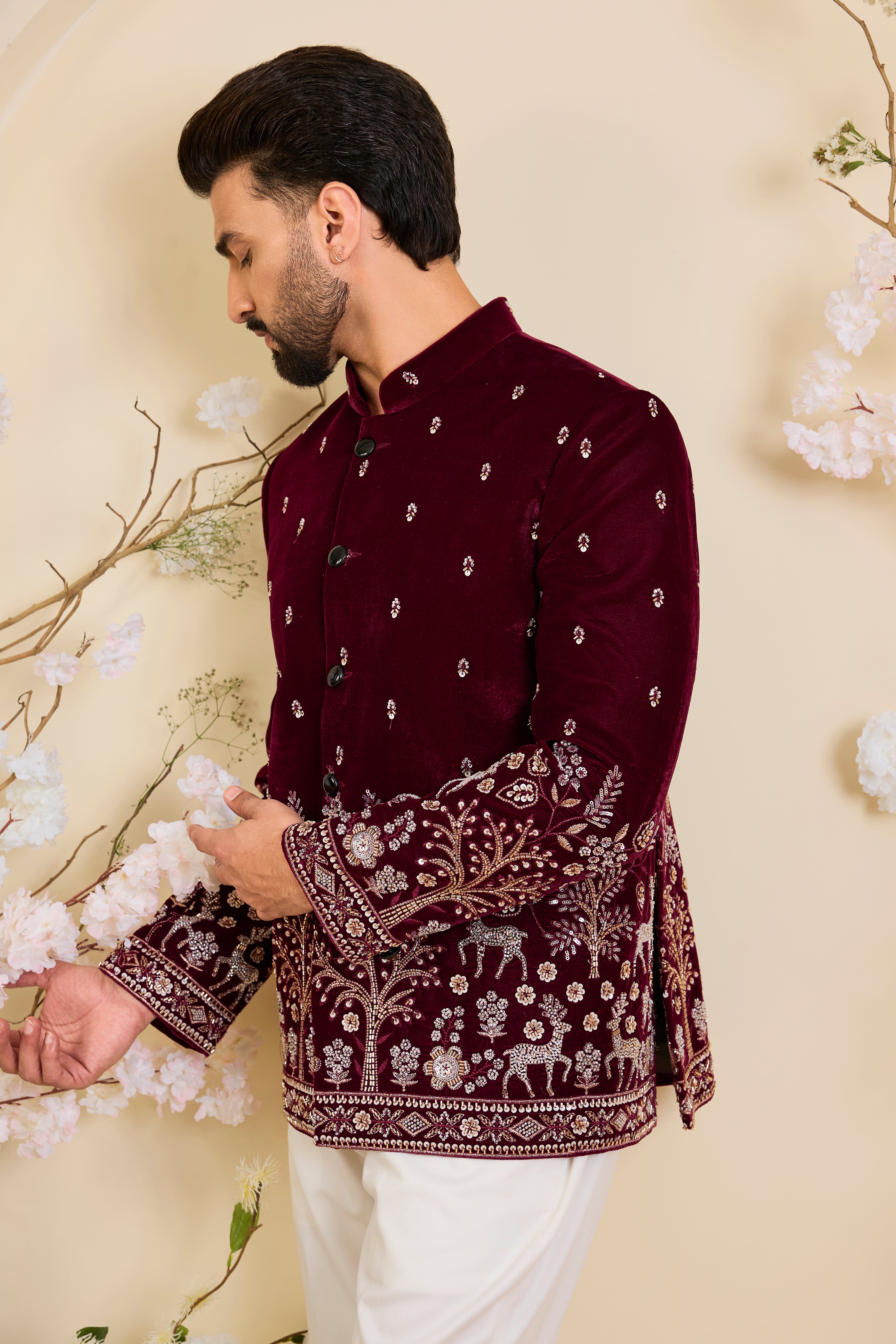 An opulent maroon bandgala , intricately hand-embroidered with dense cut dana work and elaborate flora-fauna motifs, exuding regal depth and grand sophistication.