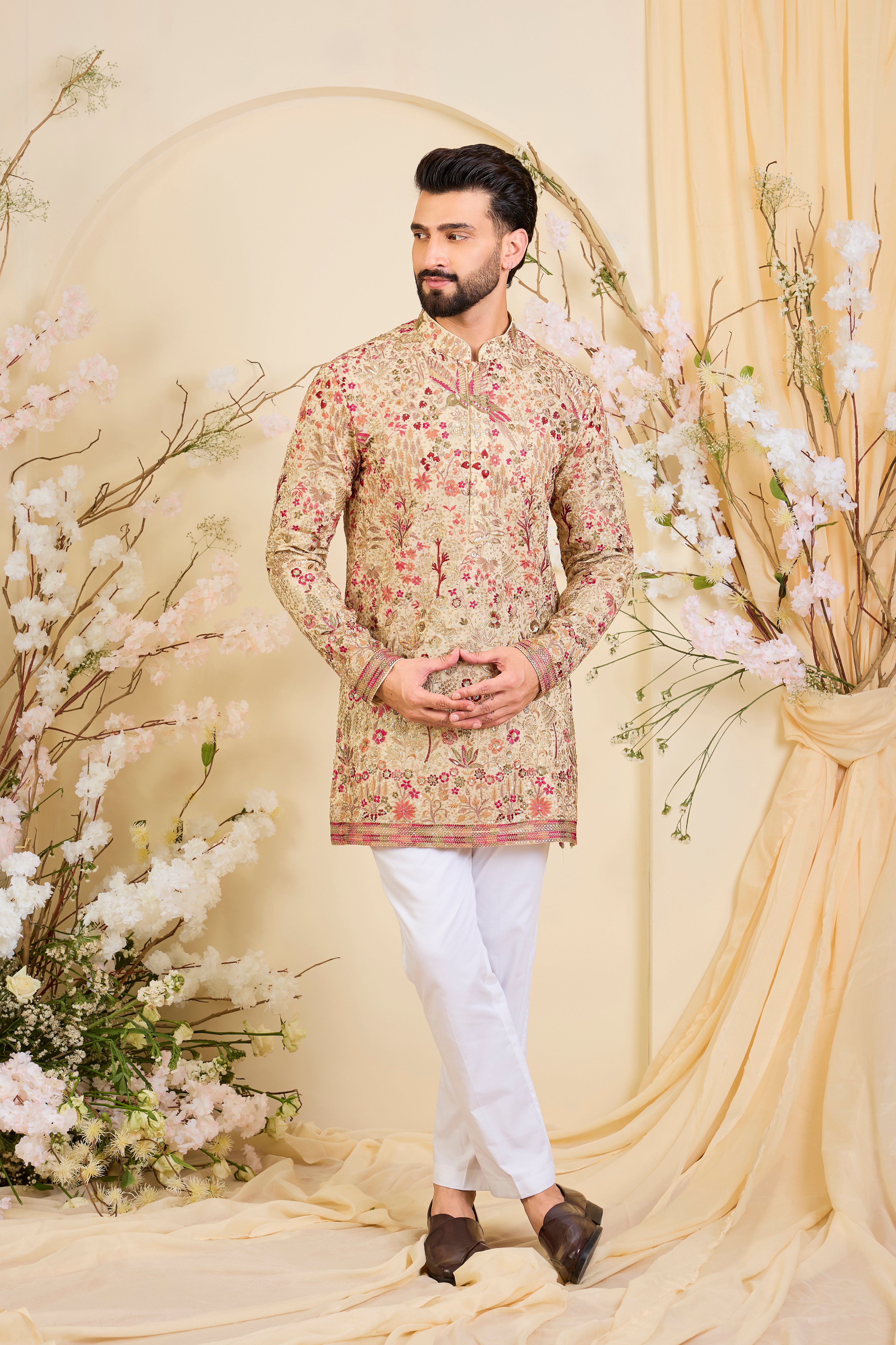 Golden-cream kurta with multicolour threadwork, zari, and sequins, creating a magical flora-fauna canvas with luminous, dreamlike elegance.