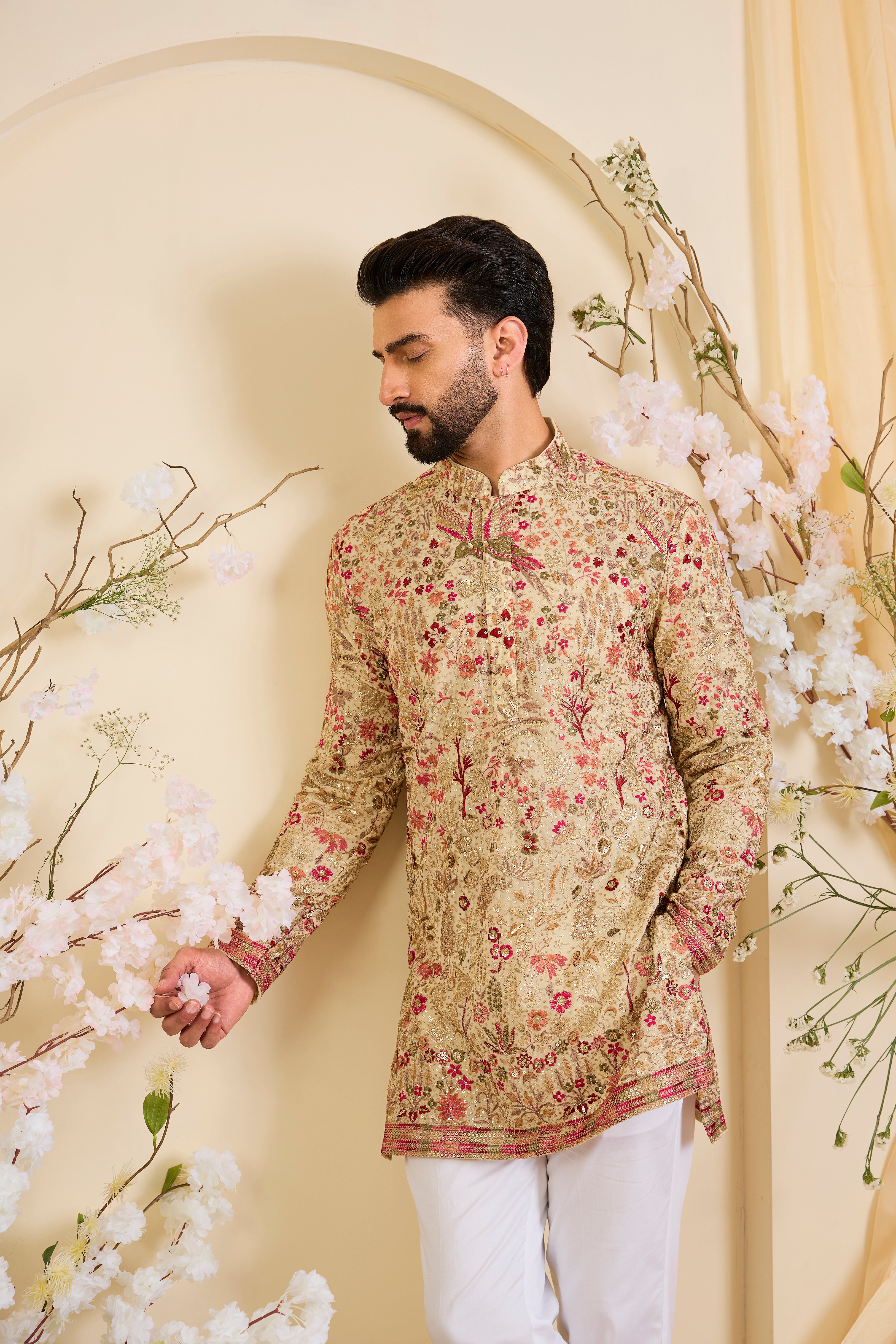 Golden-cream kurta with multicolour threadwork, zari, and sequins, creating a magical flora-fauna canvas with luminous, dreamlike elegance.