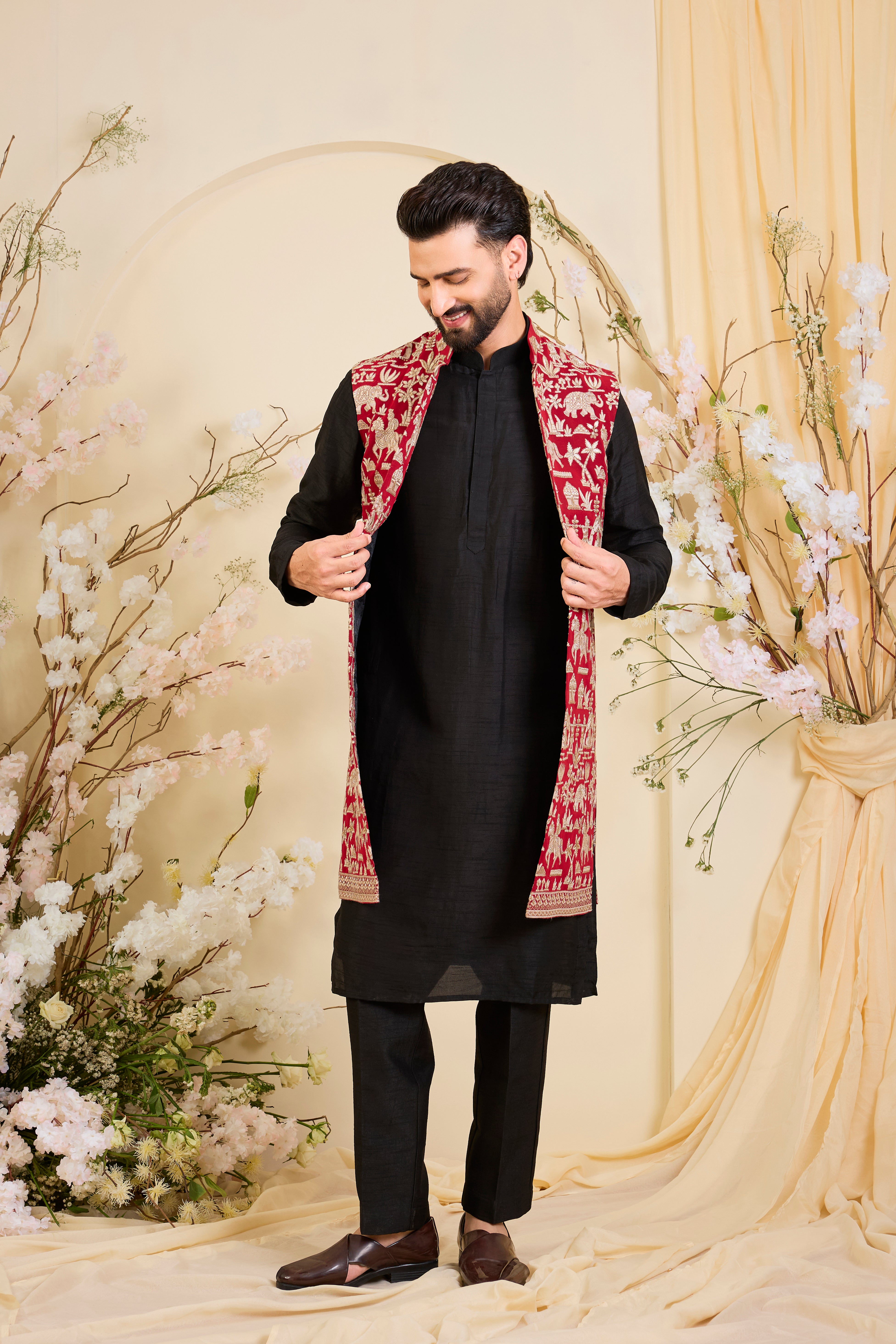 Red/pink long open jacket with intricate zari work, sequin detailing, and Mughal-era embroidery, delivering a richly layered, regal couture statement.