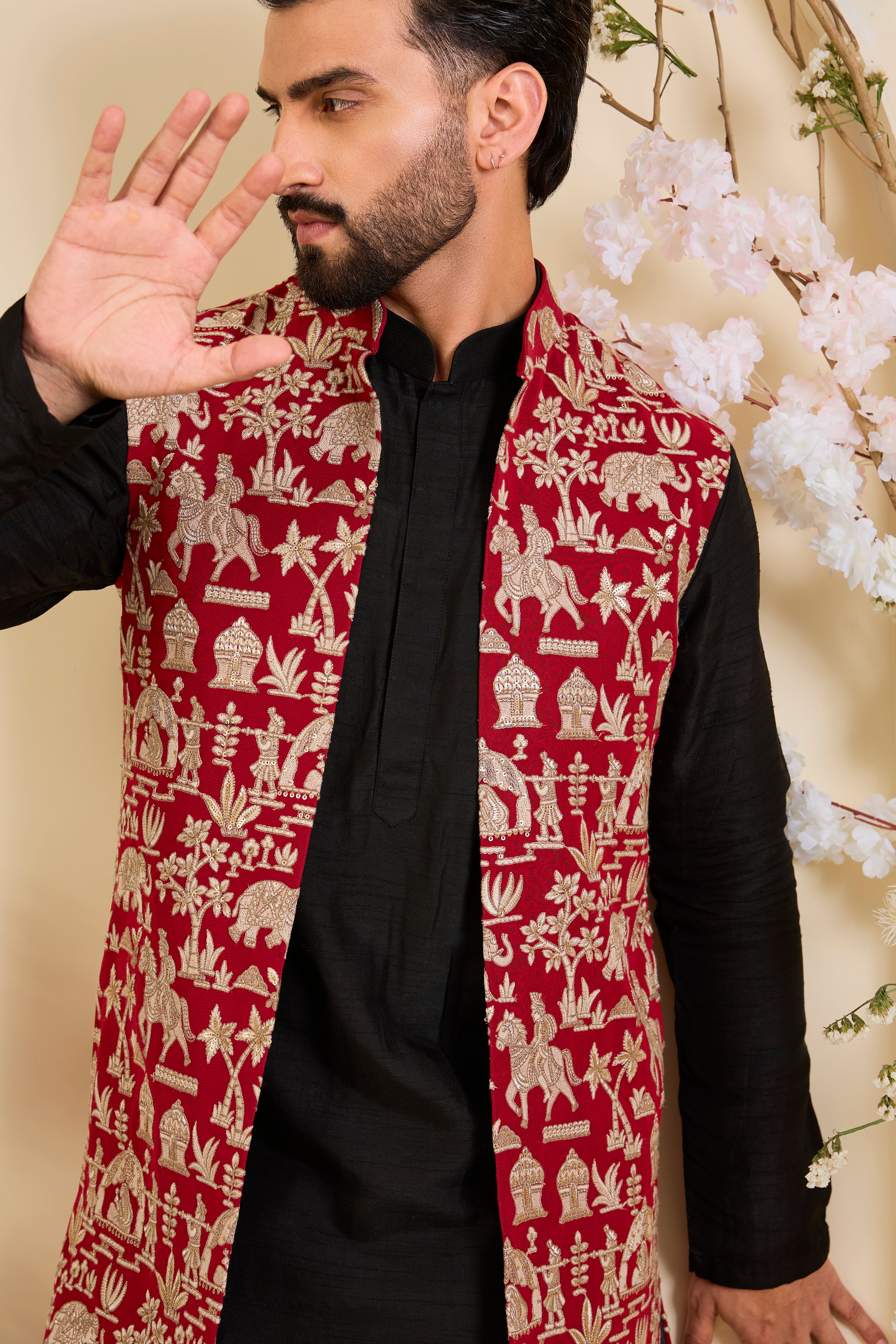 Red/pink long open jacket with intricate zari work, sequin detailing, and Mughal-era embroidery, delivering a richly layered, regal couture statement.