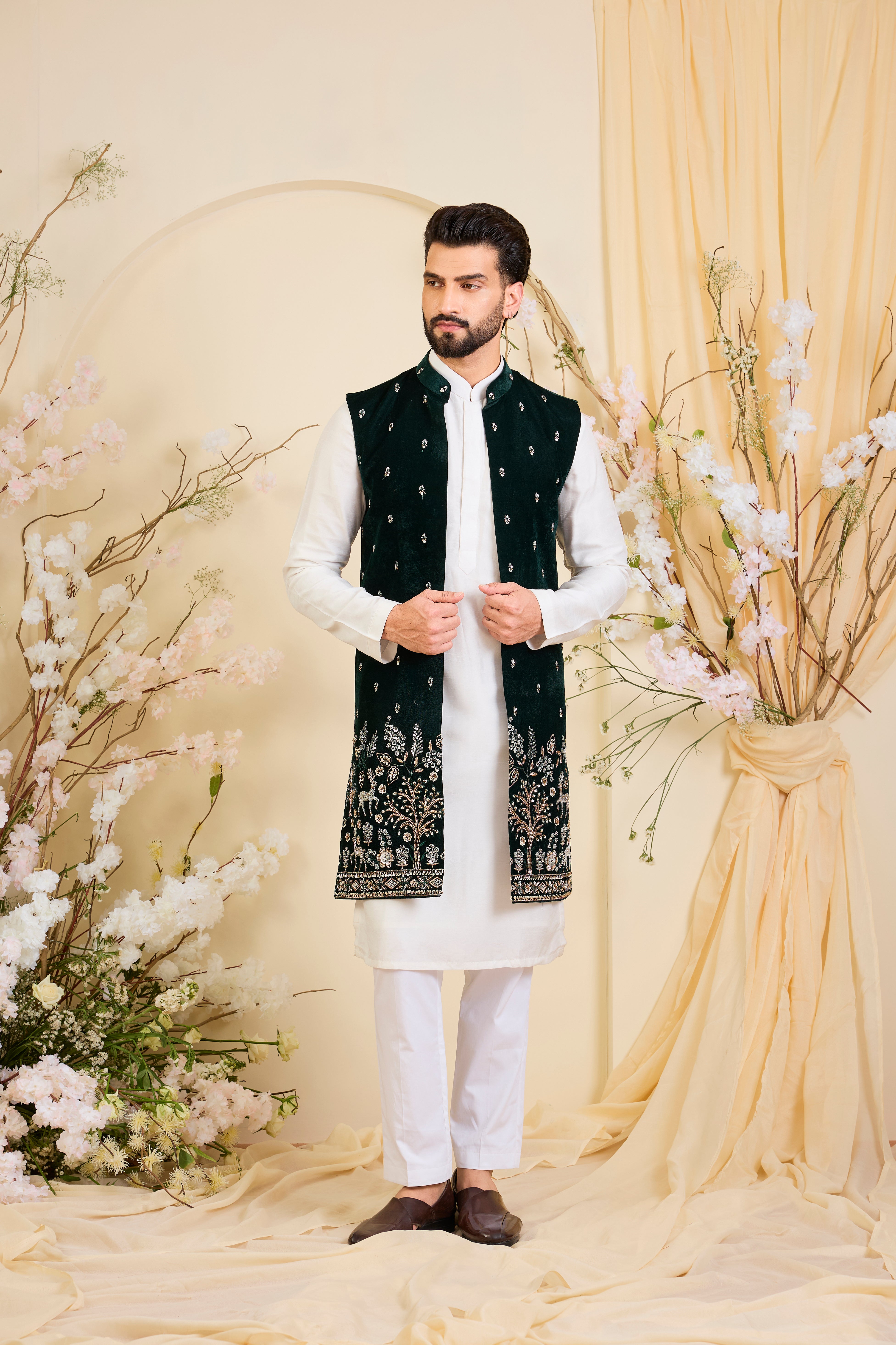 An opulent bottle green long open , intricately hand-embroidered with dense cut dana work and elaborate flora-fauna motifs, exuding regal depth and grand sophistication.