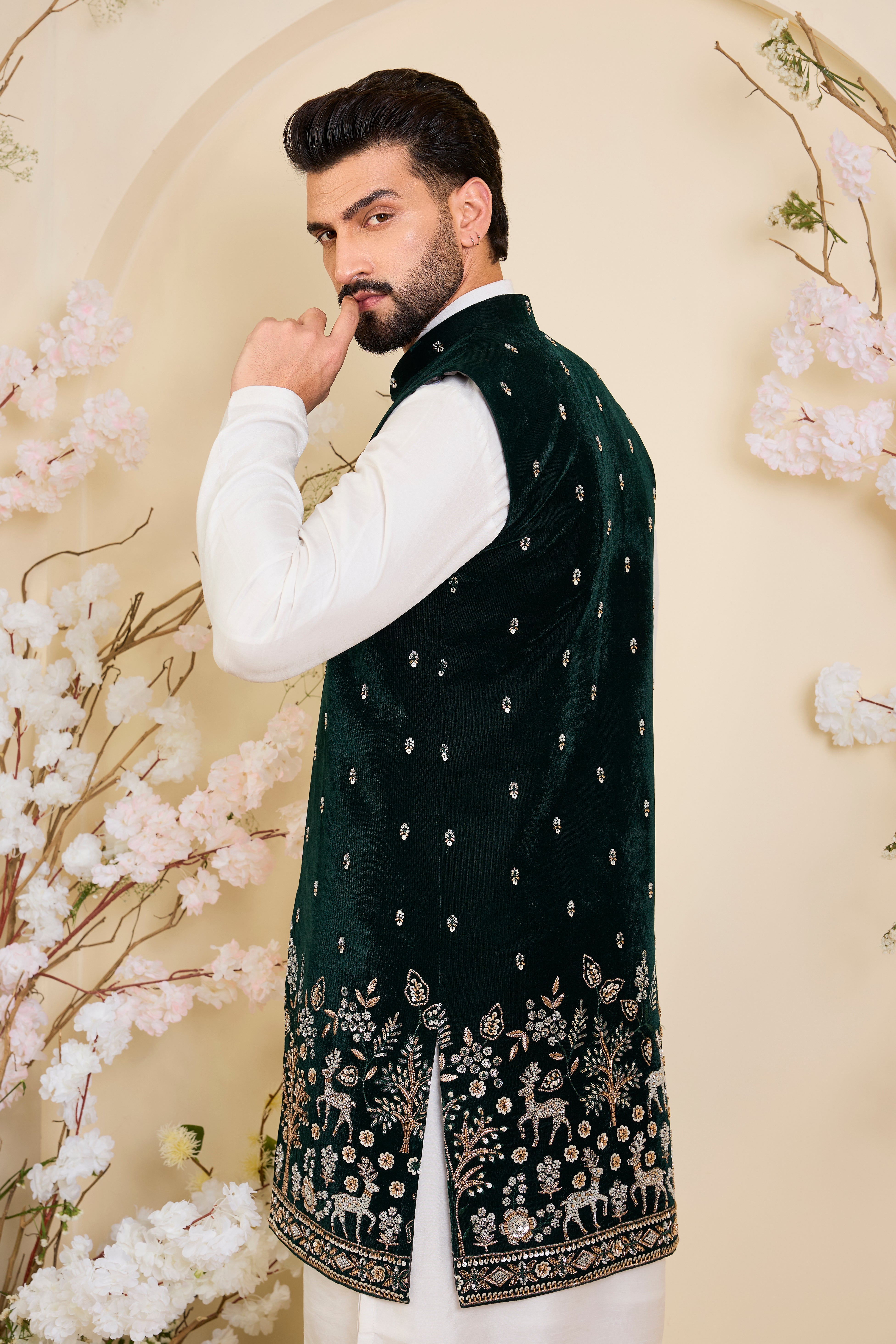 An opulent bottle green long open , intricately hand-embroidered with dense cut dana work and elaborate flora-fauna motifs, exuding regal depth and grand sophistication.