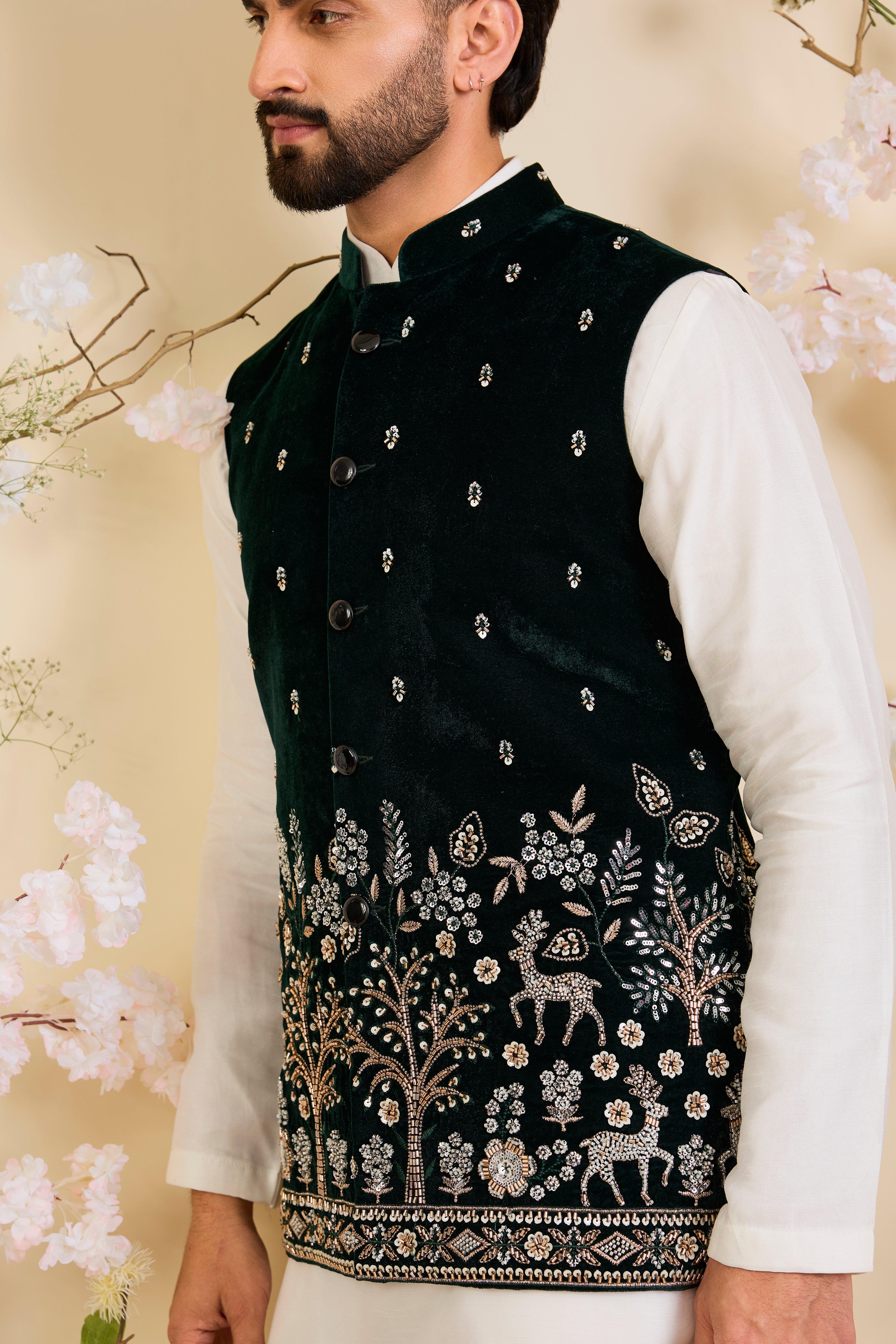An opulent bottle green nehru jacket , intricately hand-embroidered with dense cut dana work and elaborate flora-fauna motifs, exuding regal depth and grand sophistication.