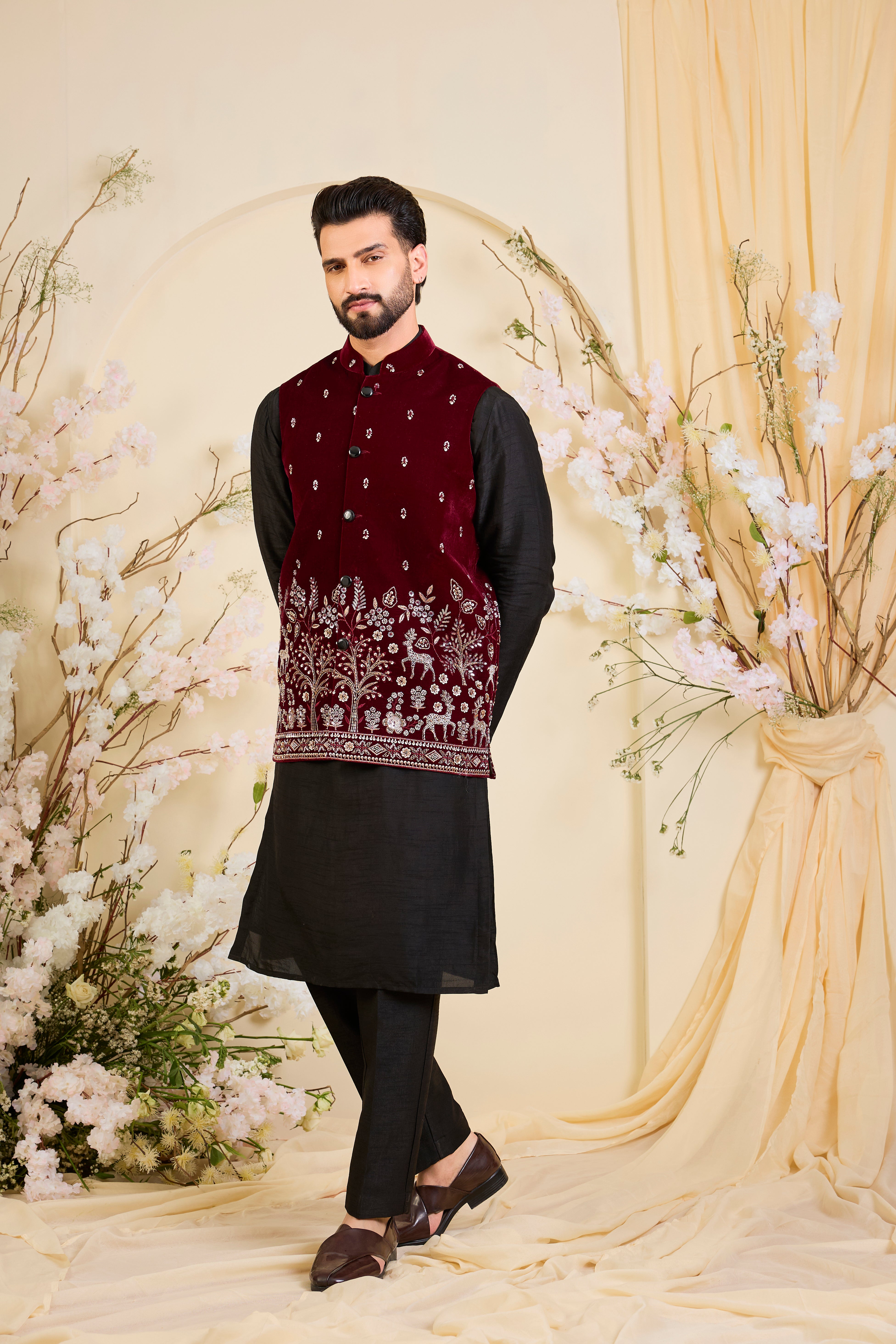 An opulent maroon nehru jacket , intricately hand-embroidered with dense cut dana work and elaborate flora-fauna motifs, exuding regal depth and grand sophistication.