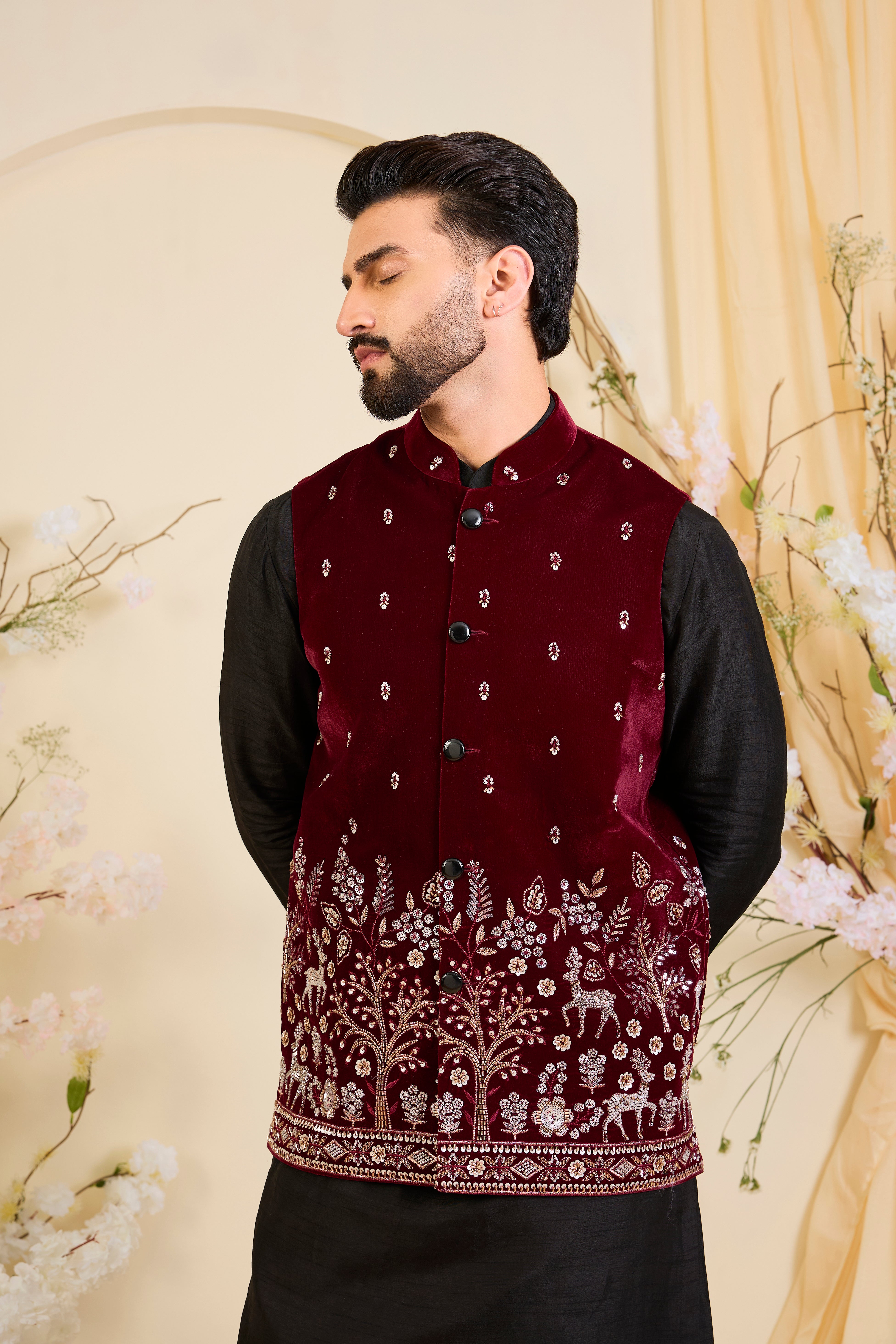 An opulent maroon nehru jacket , intricately hand-embroidered with dense cut dana work and elaborate flora-fauna motifs, exuding regal depth and grand sophistication.