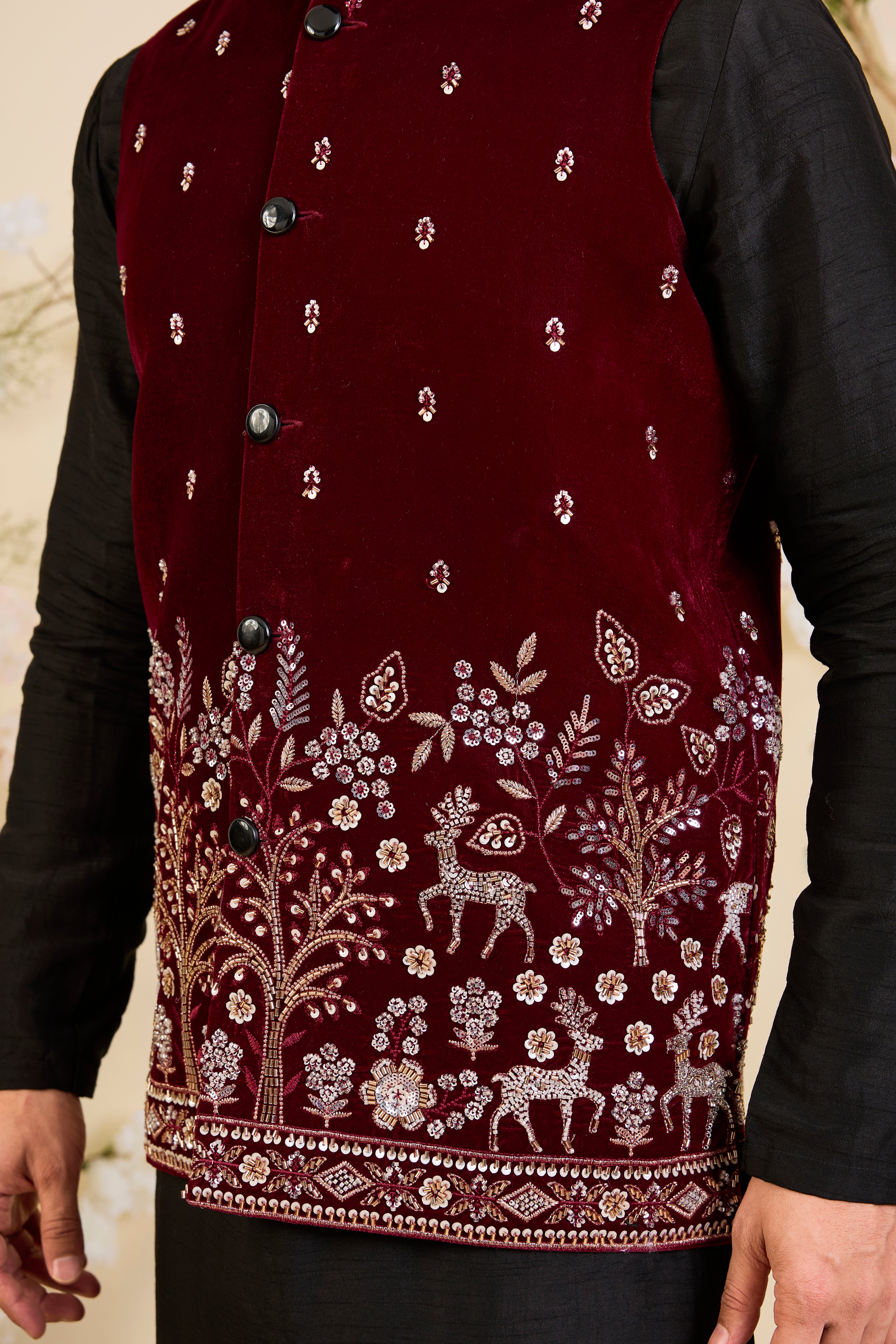 An opulent maroon nehru jacket , intricately hand-embroidered with dense cut dana work and elaborate flora-fauna motifs, exuding regal depth and grand sophistication.
