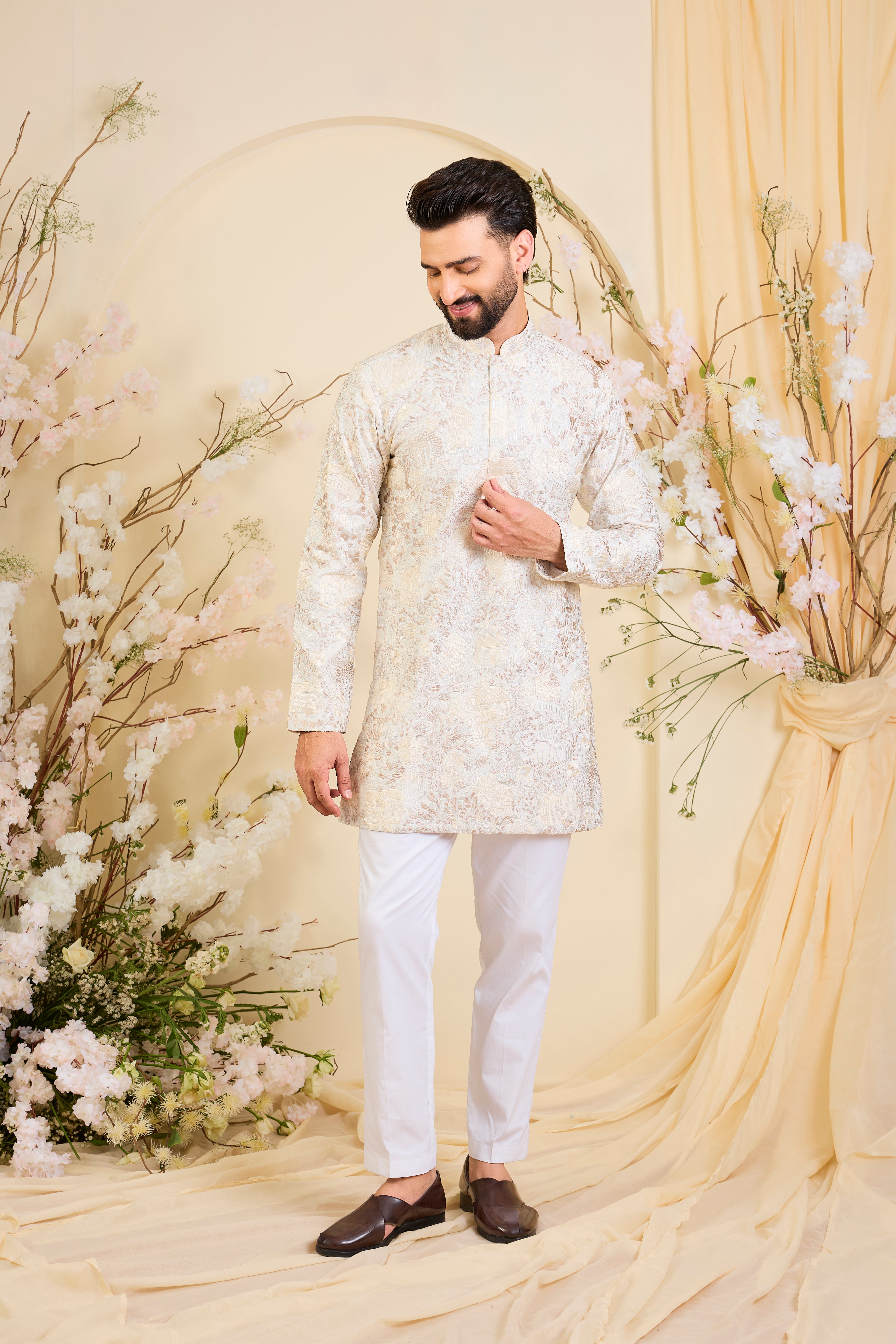 Beige-cream short kurta with intricate flora-fauna embroidery and dense threadwork, offering a refined, richly textured couture statement.