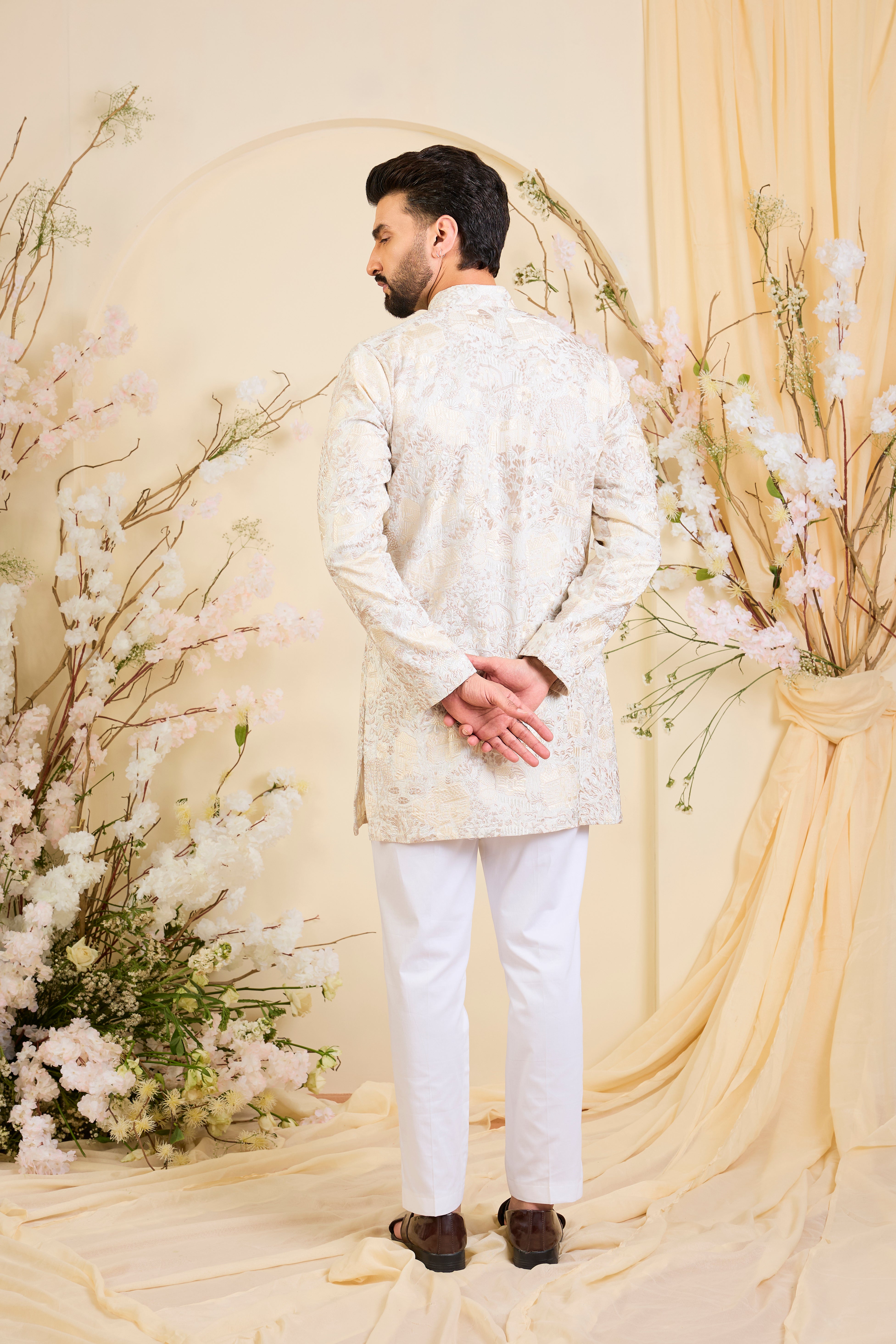 Beige-cream short kurta with intricate flora-fauna embroidery and dense threadwork, offering a refined, richly textured couture statement.