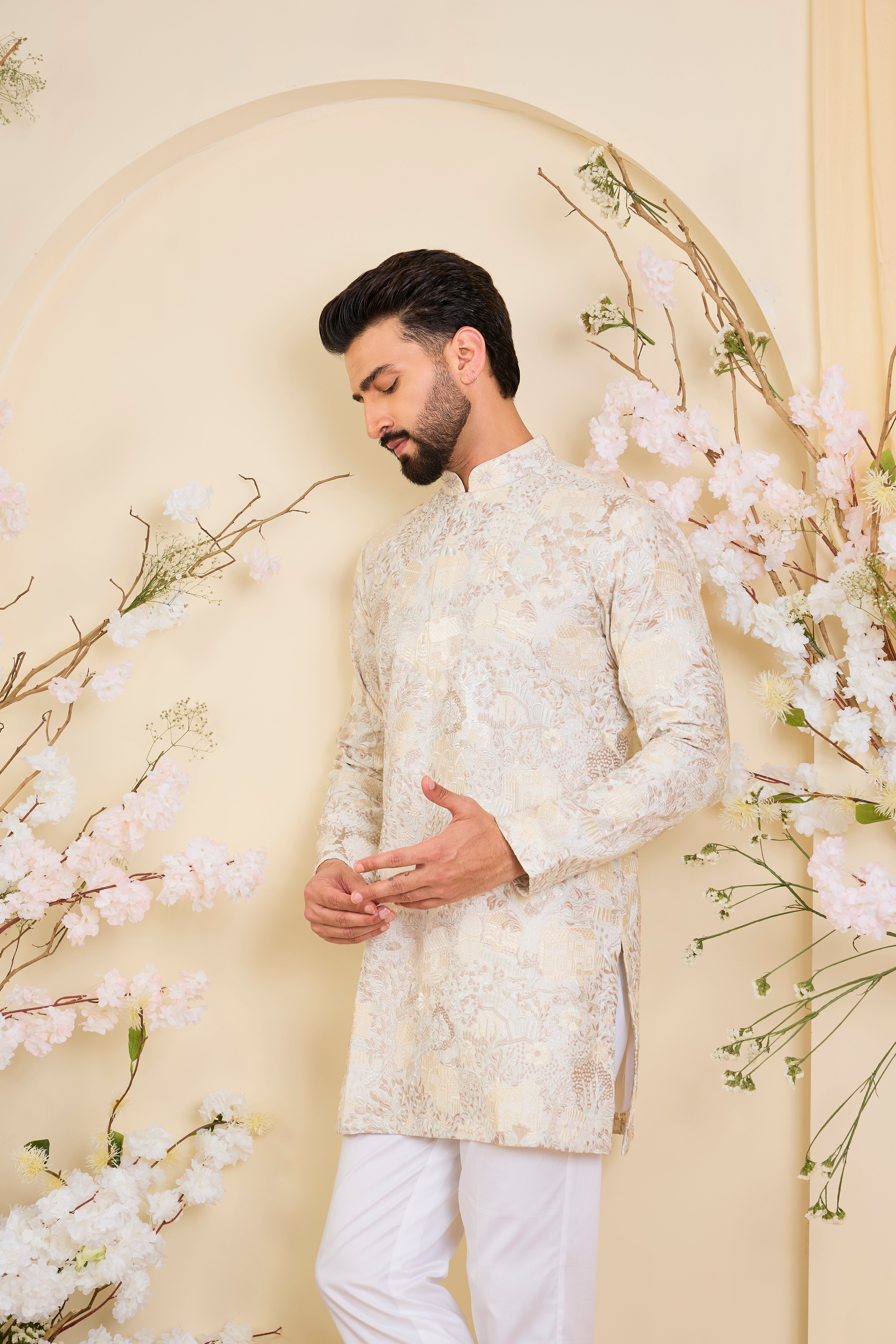 Beige-cream short kurta with intricate flora-fauna embroidery and dense threadwork, offering a refined, richly textured couture statement.