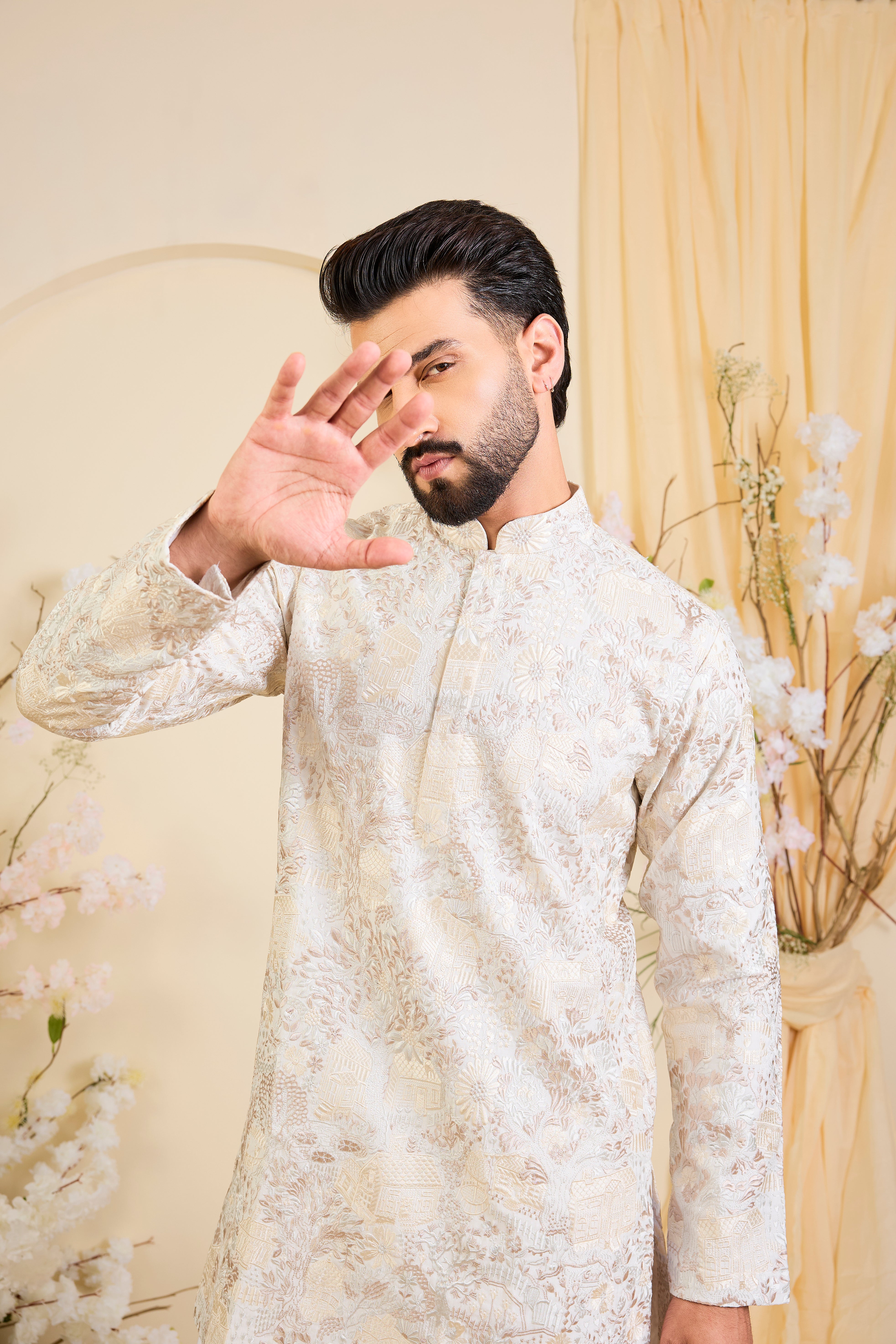 Beige-cream short kurta with intricate flora-fauna embroidery and dense threadwork, offering a refined, richly textured couture statement.