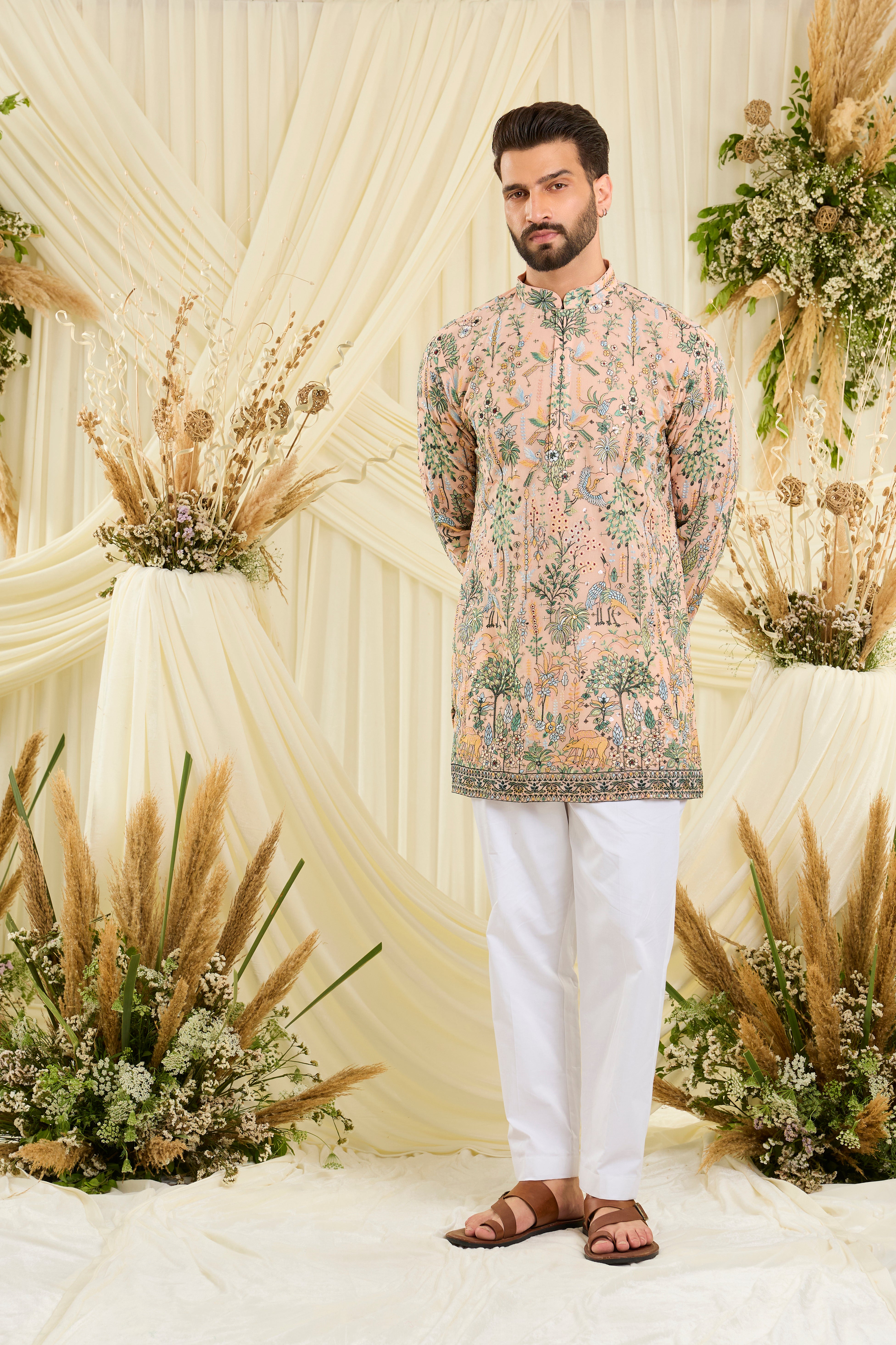 Peach short kurta with intricate flora-fauna embroidery, multicolour threadwork, and delicate sequins for a fresh, luxe festive statement.