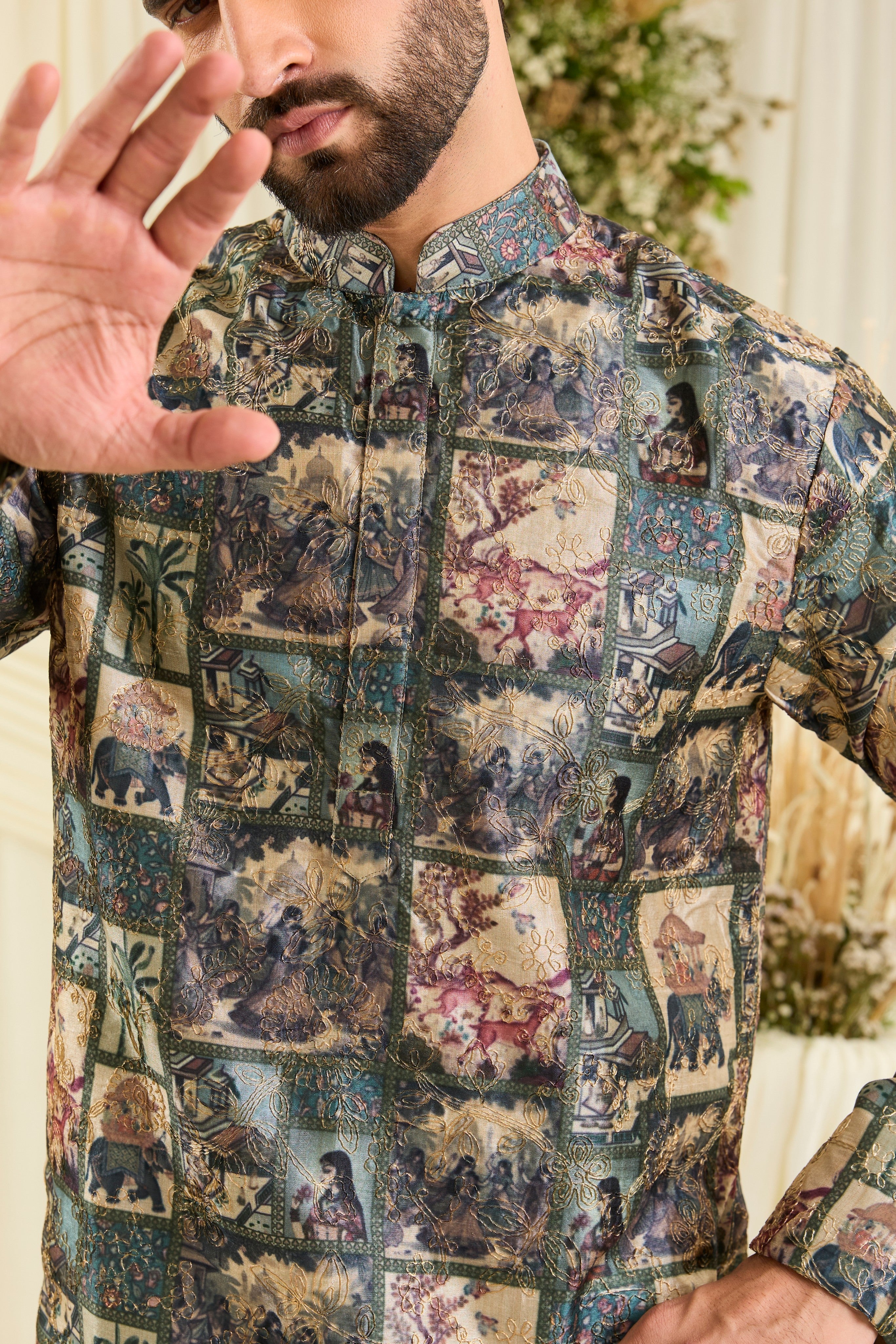 Green short kurta with multicoloured Mughal-era prints, historic motifs, and intricate aari embroidery for a bold, artistic statement.
