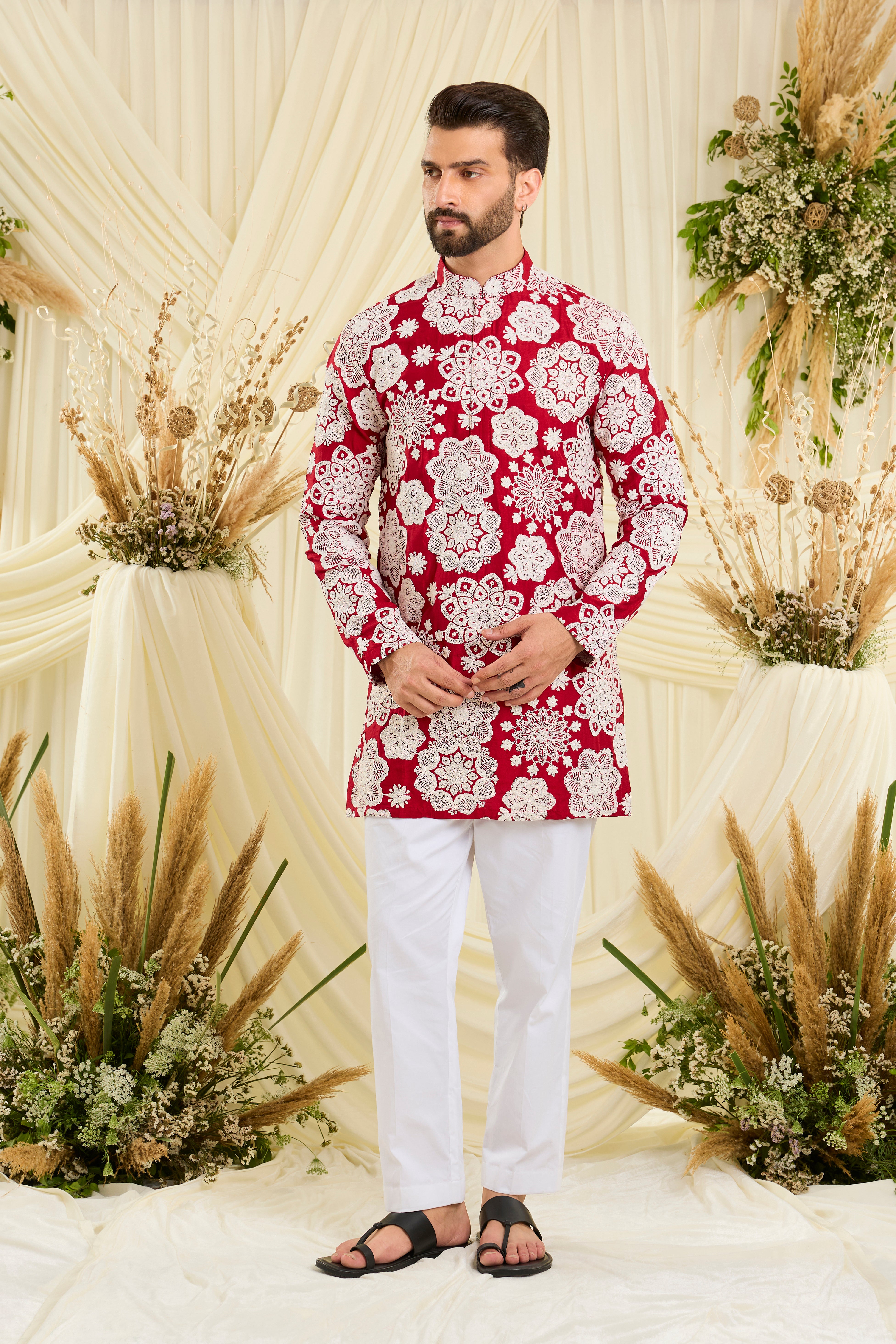 Red short kurta with intricate floral embroidery and heavy dori work, delivering a richly textured, bold festive statement.